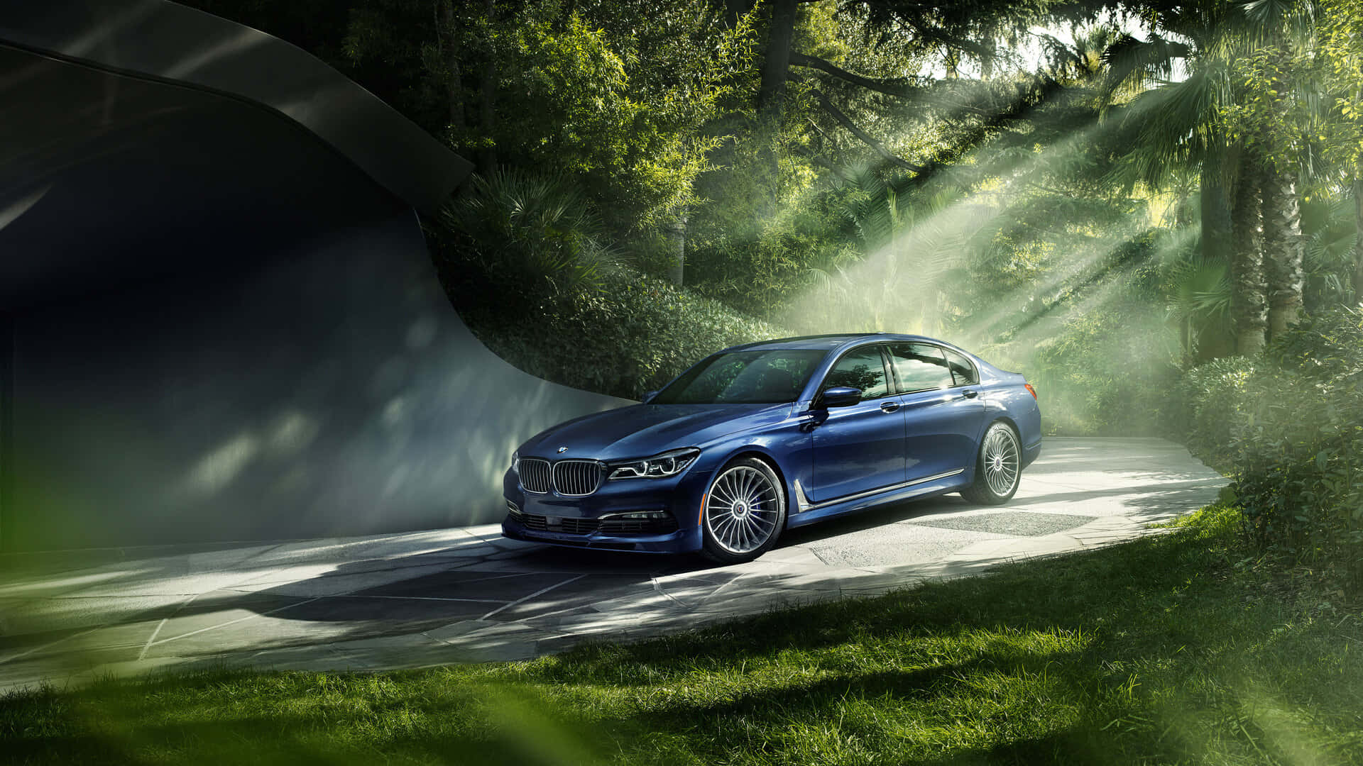 1920x1080 Bmw 桌布 壁紙 — 一輛時尚的藍色寶馬轎車沿著霧氣瀰漫的森林小徑行駛，金色的陽光穿過樹木灑落下來。