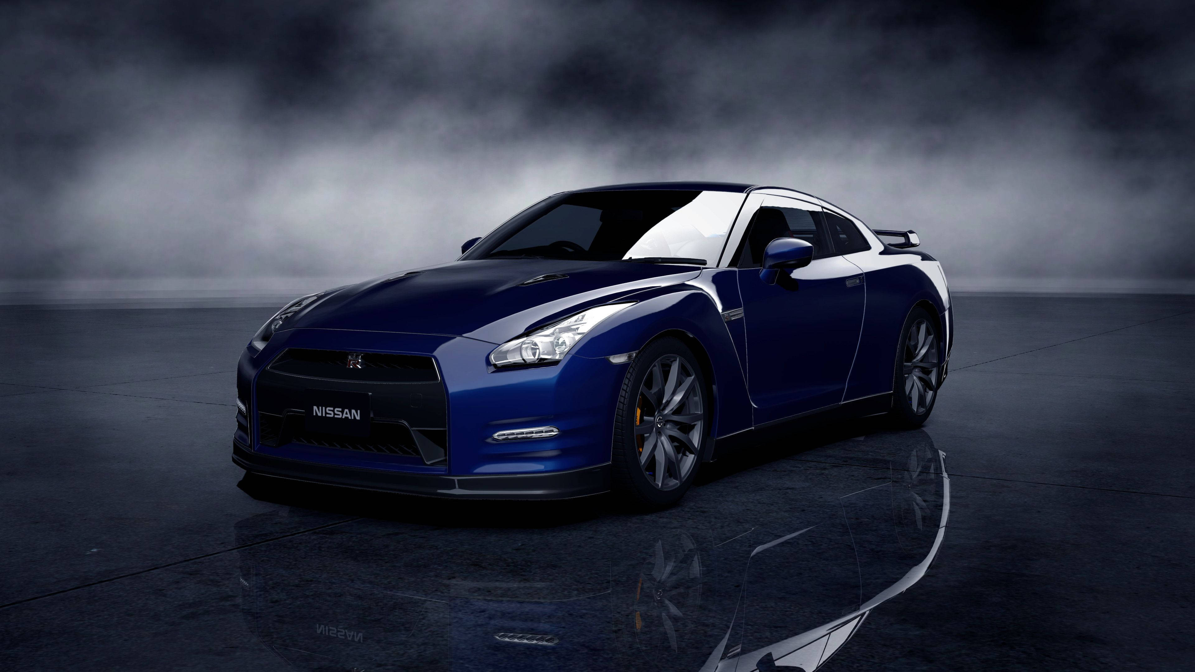 Nissan 桌布 壁紙 — 一輛時尚的藍色日產GT-R跑車在戲劇性燈光下，於帶有霧氣背景的反射性深色地板上閃閃發光。