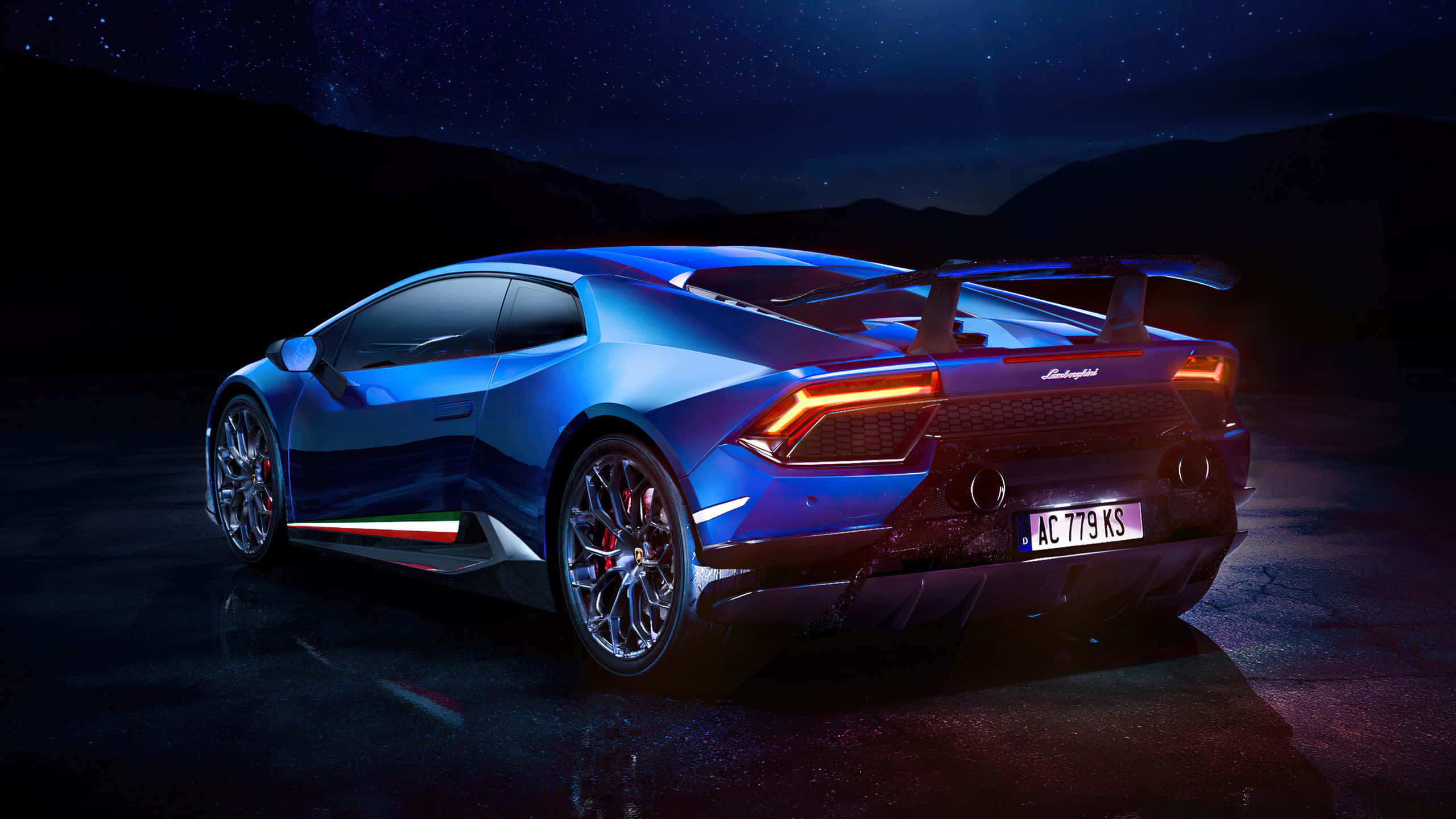 桌布 壁紙 — 一輛時尚的藍色藍寶堅尼 Huracán Performante 在星空下閃耀，橙色尾燈在黑暗山脈背景下發光。