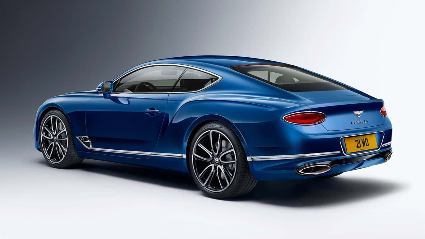 1366x768 Bentley 桌布 壁紙 — 一輛時尚的藍色賓利 Continental GT 雙門轎跑車在攝影棚燈光下閃耀，展現其優雅曲線和鍍鉻裝飾。