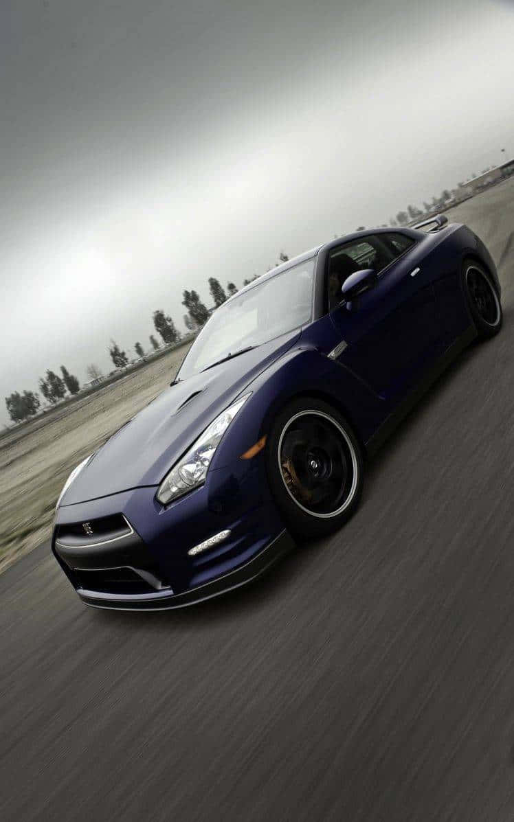 汽車 4K 桌布 壁紙 — 一輛時尚的藍色跑車在陰天籠罩下，沿著灰色瀝青道路高速行駛，呈現模糊動態效果。