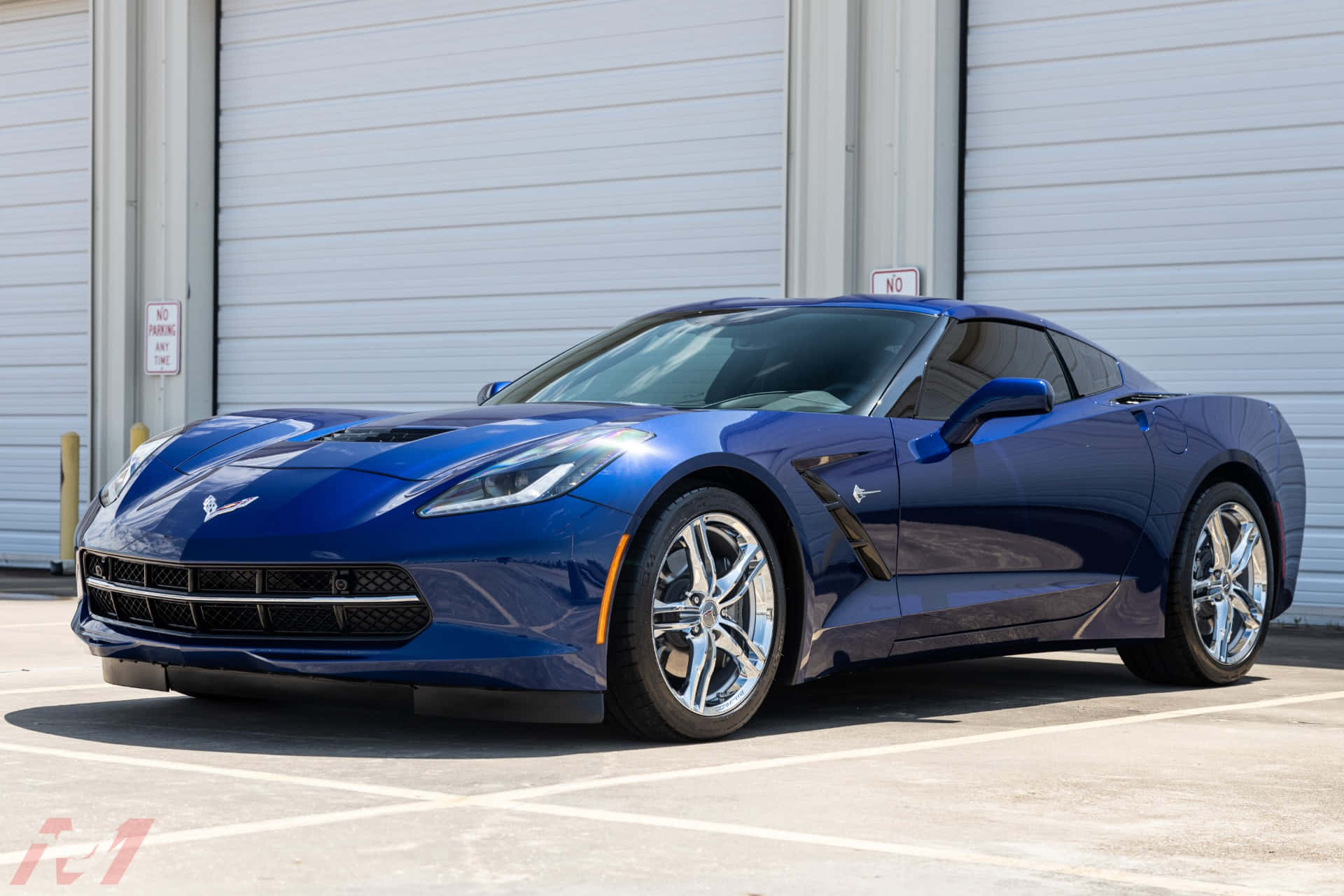 Chevrolet Corvette Stingray 桌布 壁紙 — 一輛時尚的藍色雪佛蘭克爾維特跑車在陽光明媚的日子停放在白色工業車庫門前。