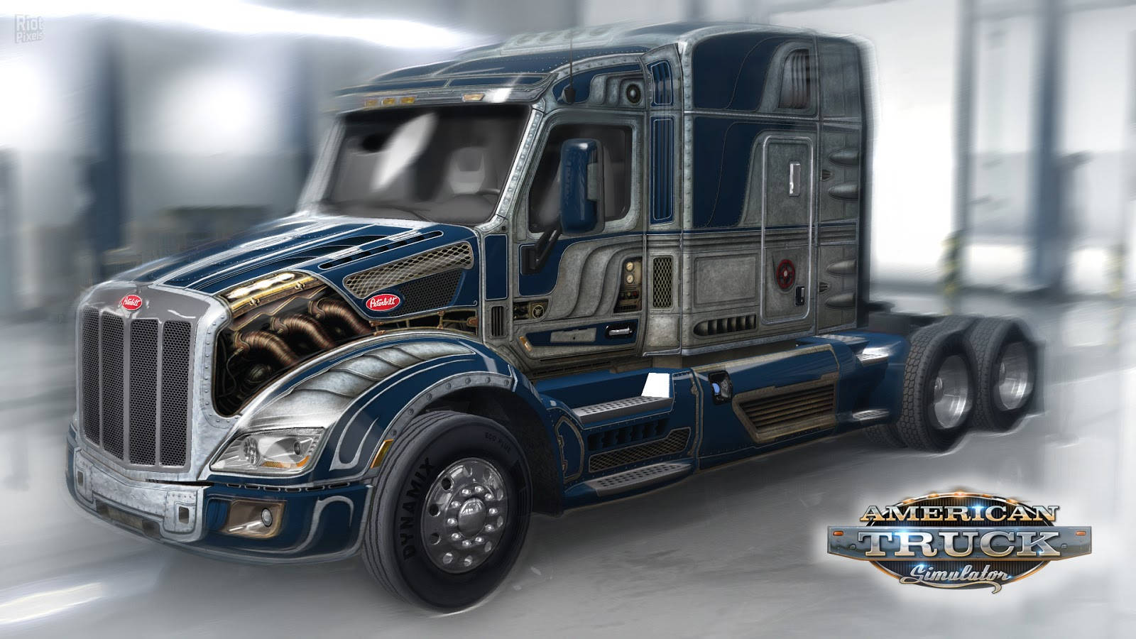 American Truck Simulator 桌布 壁紙 — 一輛時尚的藍銀色Peterbilt半掛卡車，帶有鍍鉻裝飾和詳細的引擎格柵，在明亮的倉庫內行駛。