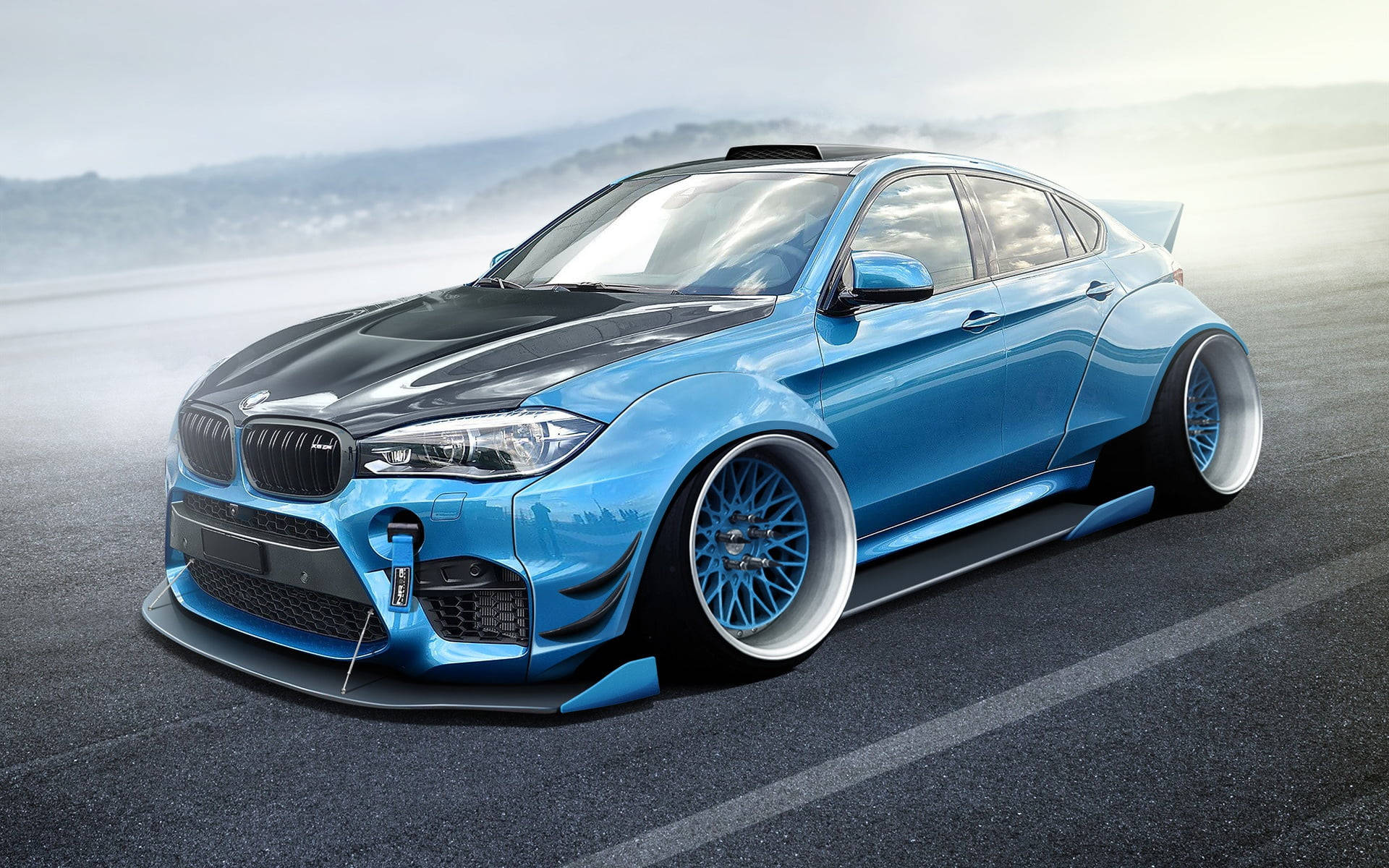 m 桌布 壁紙 — 一輛時尚的藍黑改裝BMW轎車，配備定制輪圈和空氣動力學車身套件，停在霧氣瀰漫的瀝青路上。