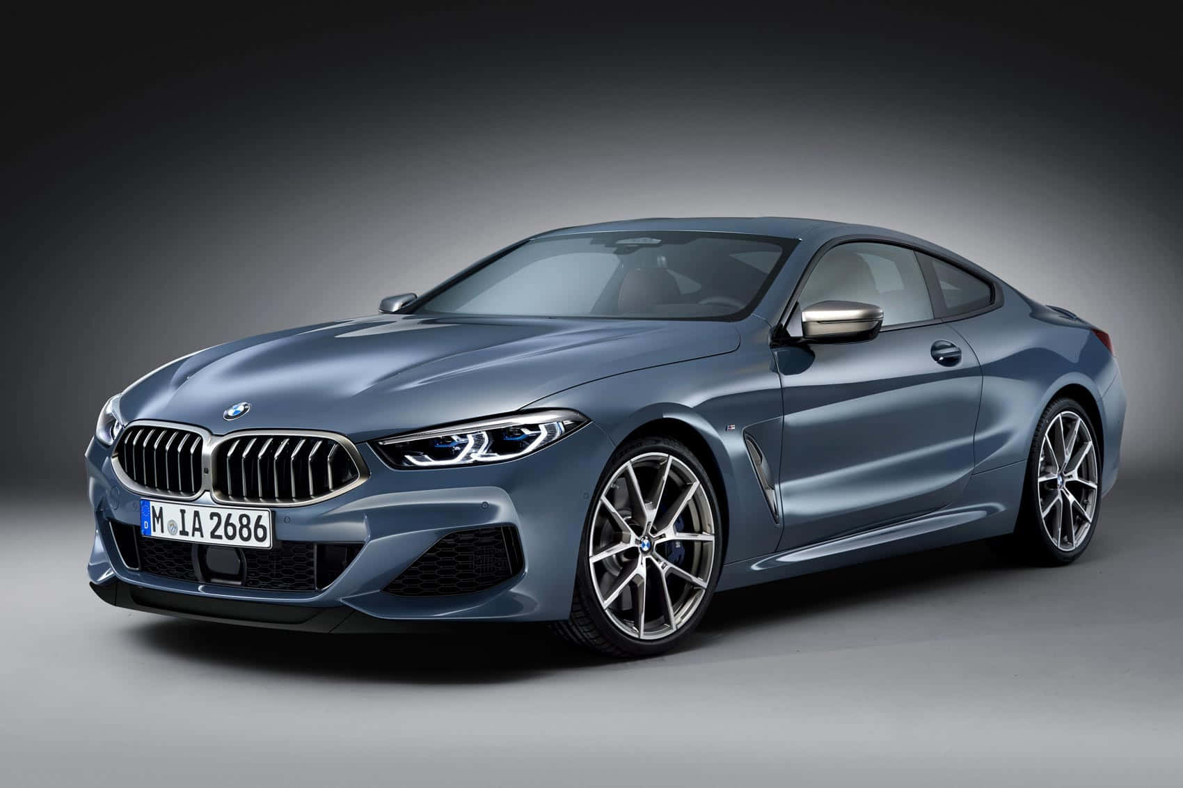 Bmw 8 Series 桌布 壁紙 — 一輛時尚的金屬藍色BMW 8系列轎跑車在漸變灰色背景下的攝影棚燈光中閃閃發光。