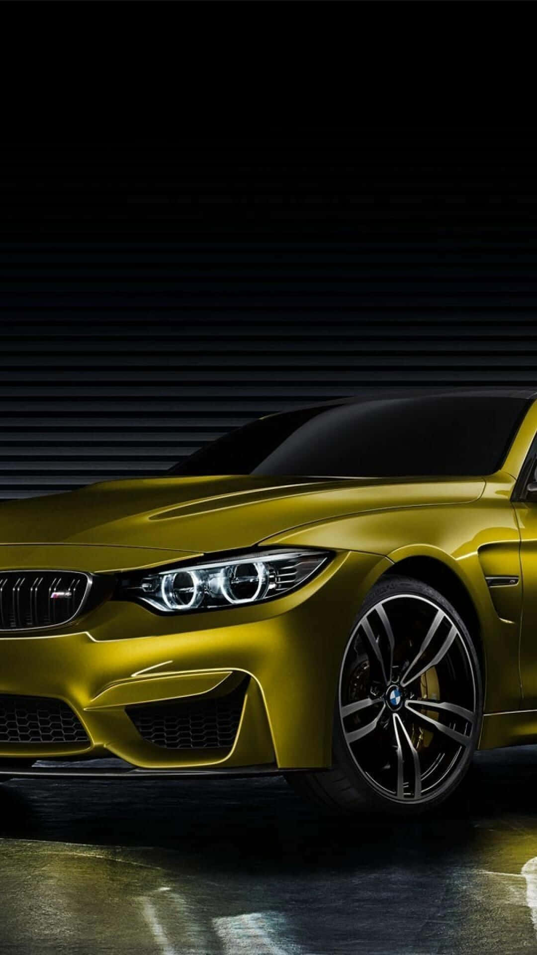 Pixel 3 Bmw 桌布 壁紙 — 一輛時尚的金色BMW M4跑車在戲劇性燈光下，在黑暗的工業背景下閃耀。