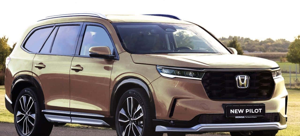 2023 Honda Pilot 桌布 壁紙 — 一輛時尚的金色本田Pilot SUV在明亮的日光下停泊在碎石路上，背景有樹木和開闊的田野。