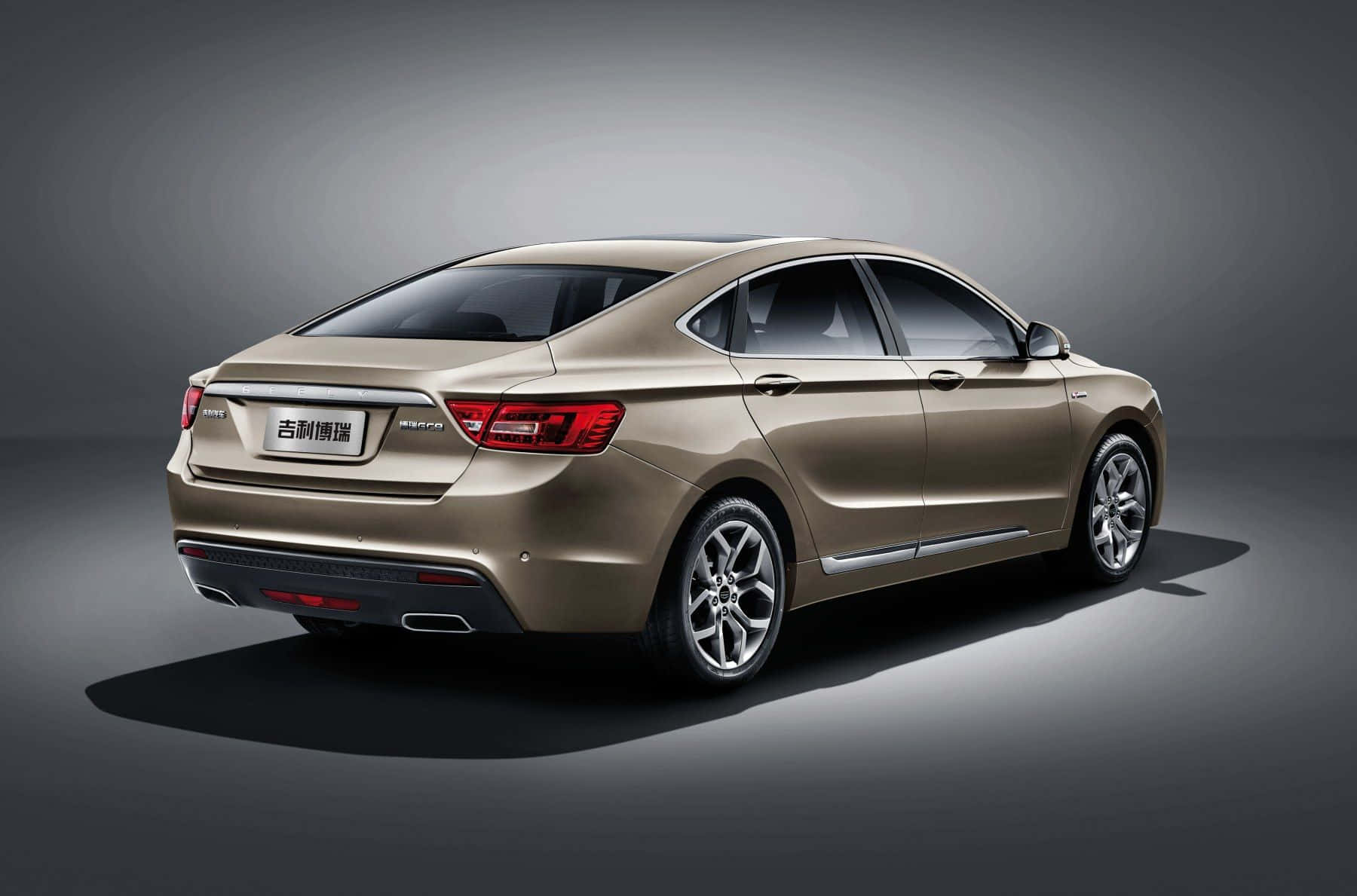 Geely 桌布 壁紙 — 一輛時尚的金色轎車在工作室中展示，配有戲劇性的燈光和深色漸變背景。