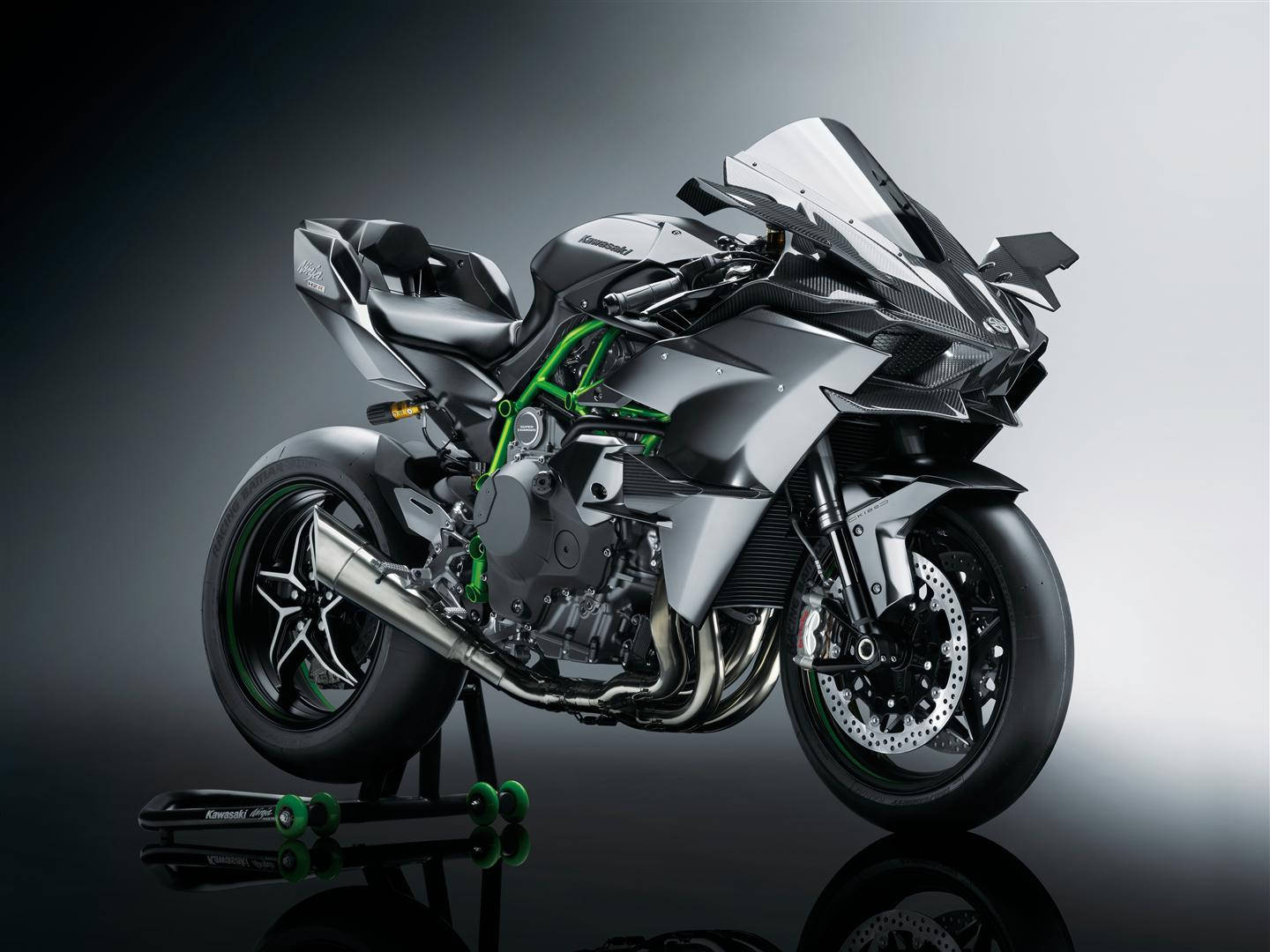 展示中的銀綠色Kawasaki運動摩托車，帶有反射表面。 — 機車 壁紙