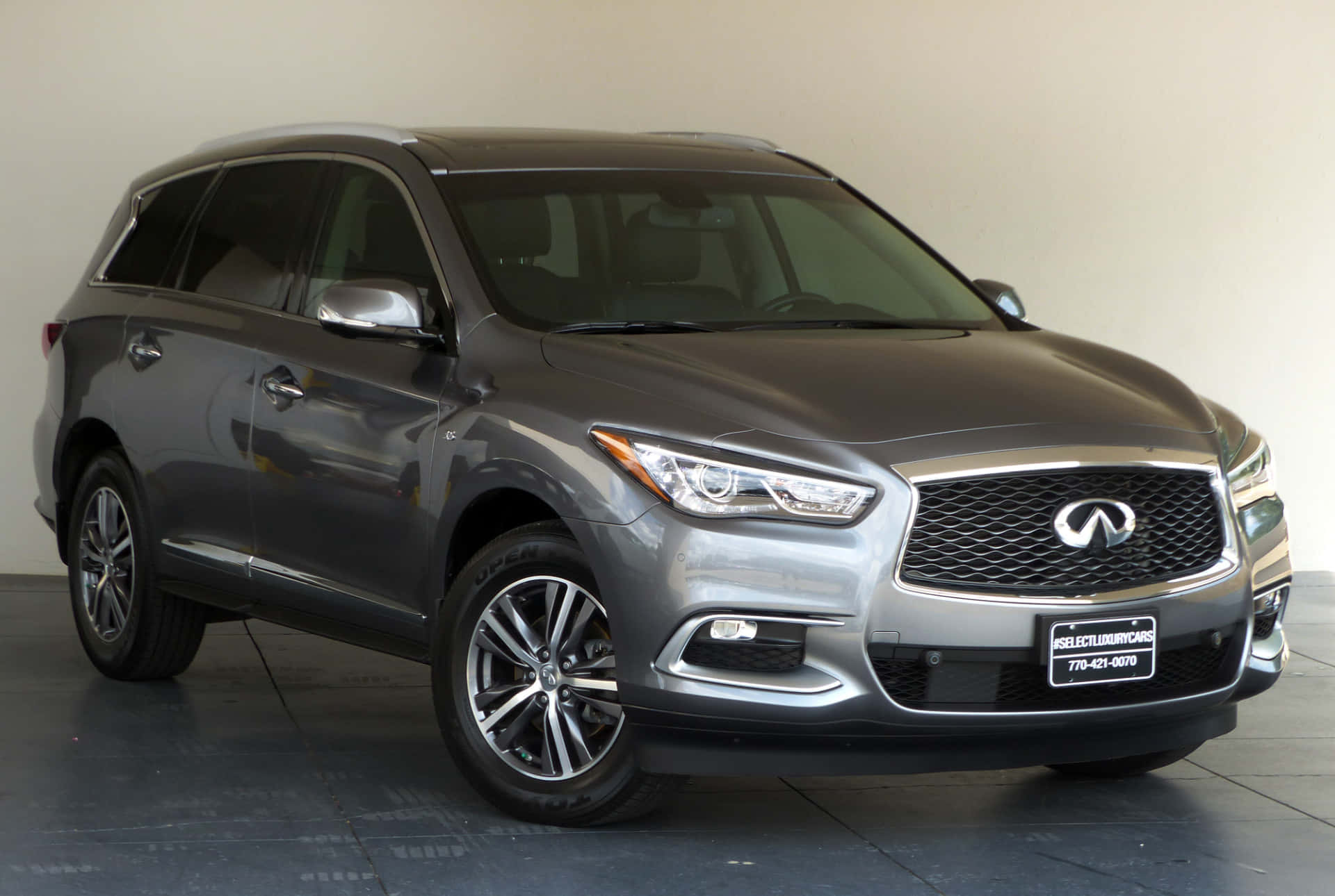 Infiniti Qx60 桌布 壁紙 — 一輛時尚的銀色 Infiniti QX60 SUV 在乾淨的室內攝影棚中展示，配有反光地板和柔和燈光。
