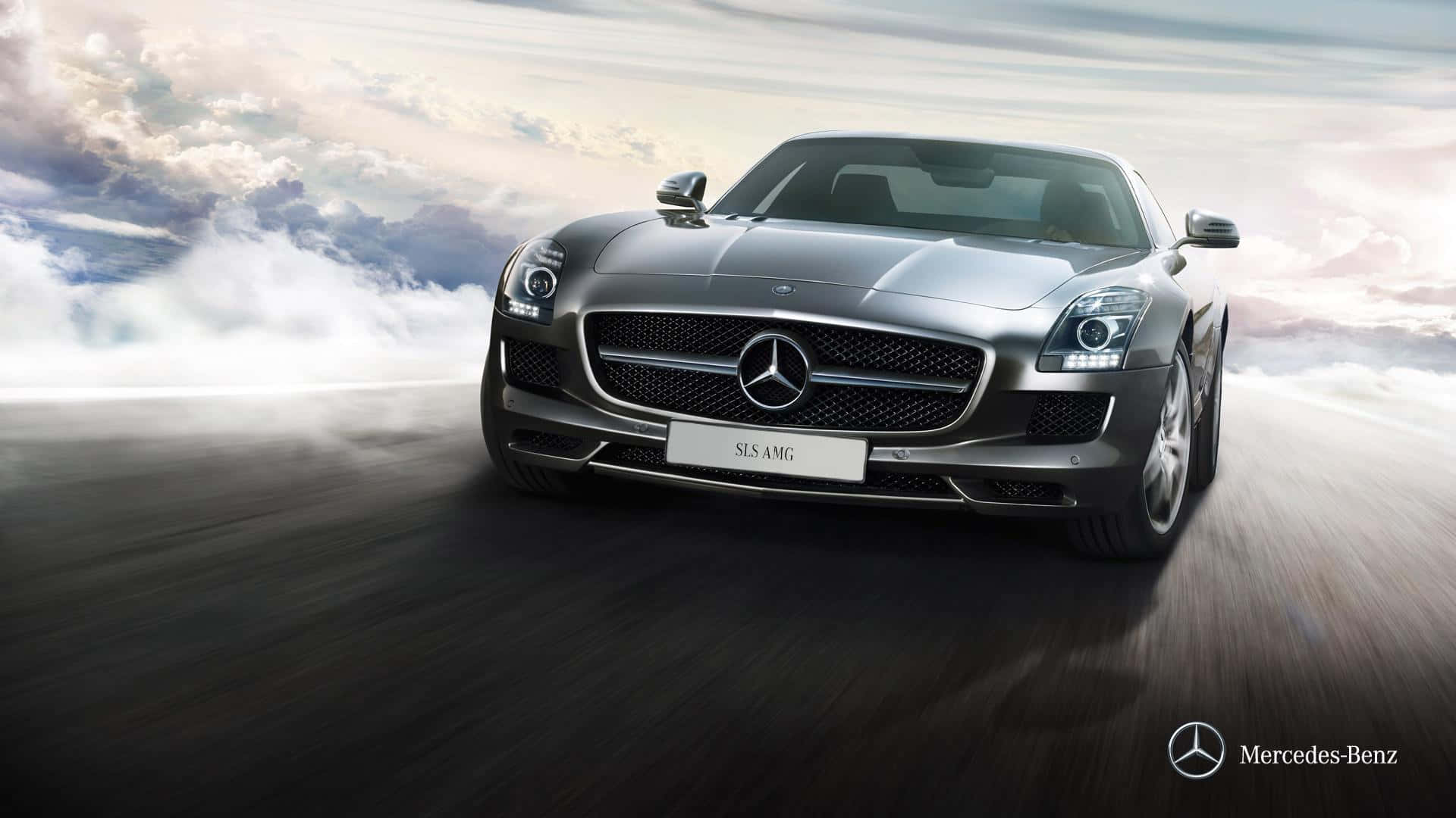 Mercedes 桌布 壁紙 — 一輛時尚的銀色 Mercedes-Benz SLS AMG 跑車在模糊的道路上奔馳，背景是戲劇性的多雲天空。