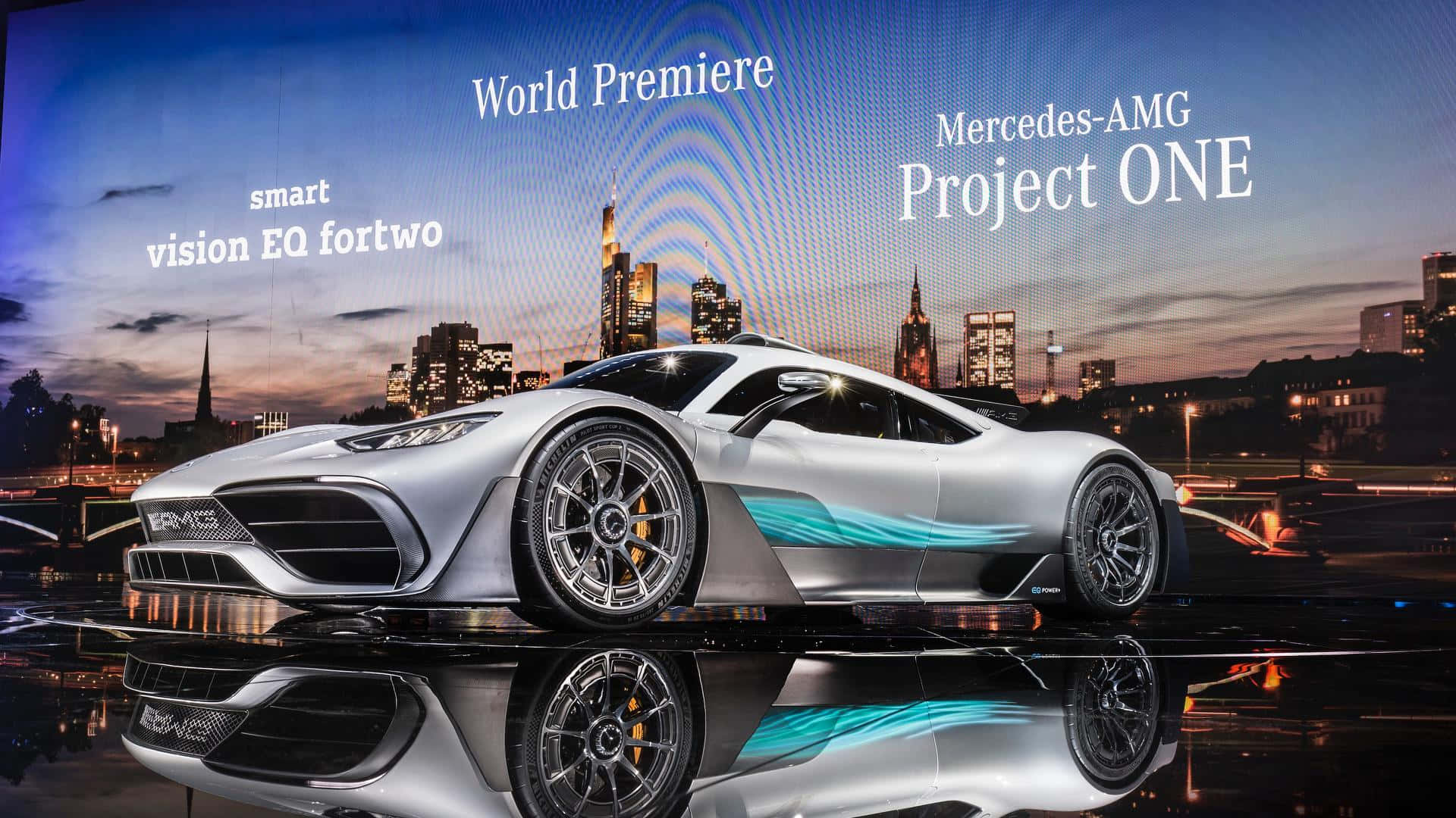 Mercedes 桌布 壁紙 — 一輛時尚的銀色 Mercedes-AMG Project ONE 超級跑車在暮色城市燈光下閃耀，映照在濕潤的反光路面上。