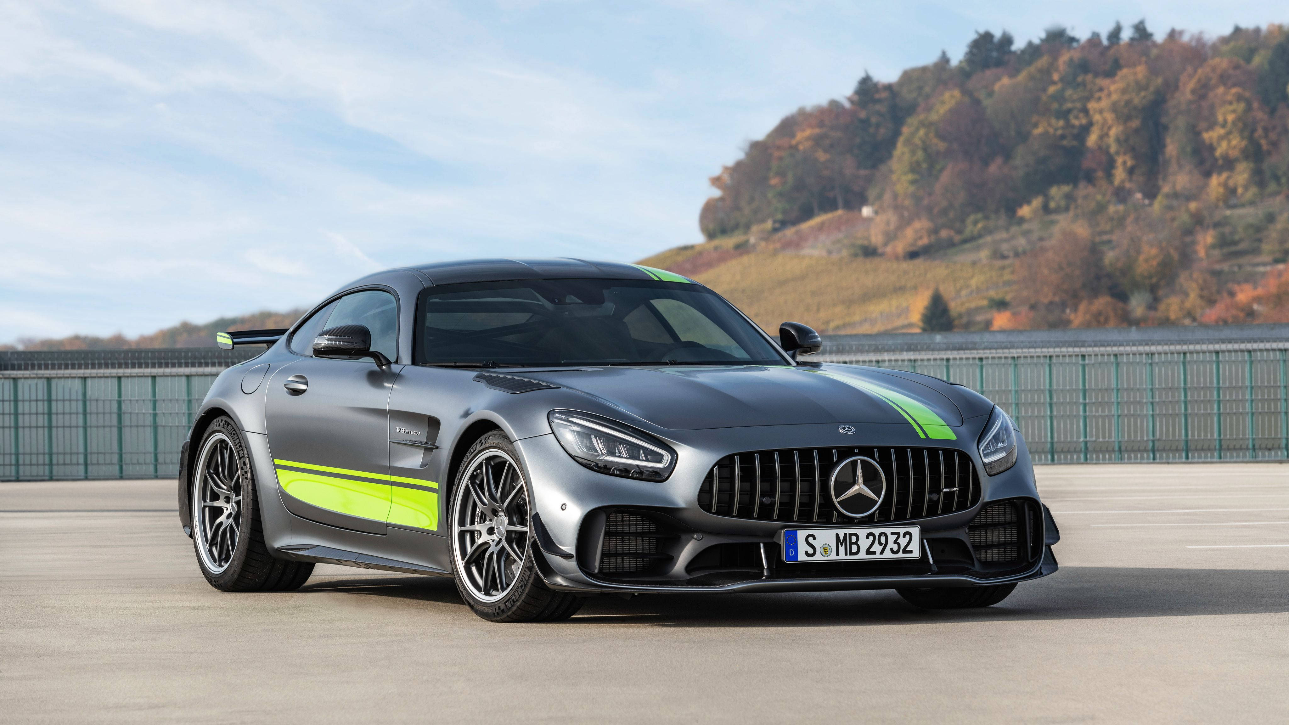 Gtr 桌布 壁紙 — 一輛時尚的銀色 Mercedes-AMG GT R 跑車，帶有螢光綠色條紋，停在混凝土表面上，背景是秋日山丘。