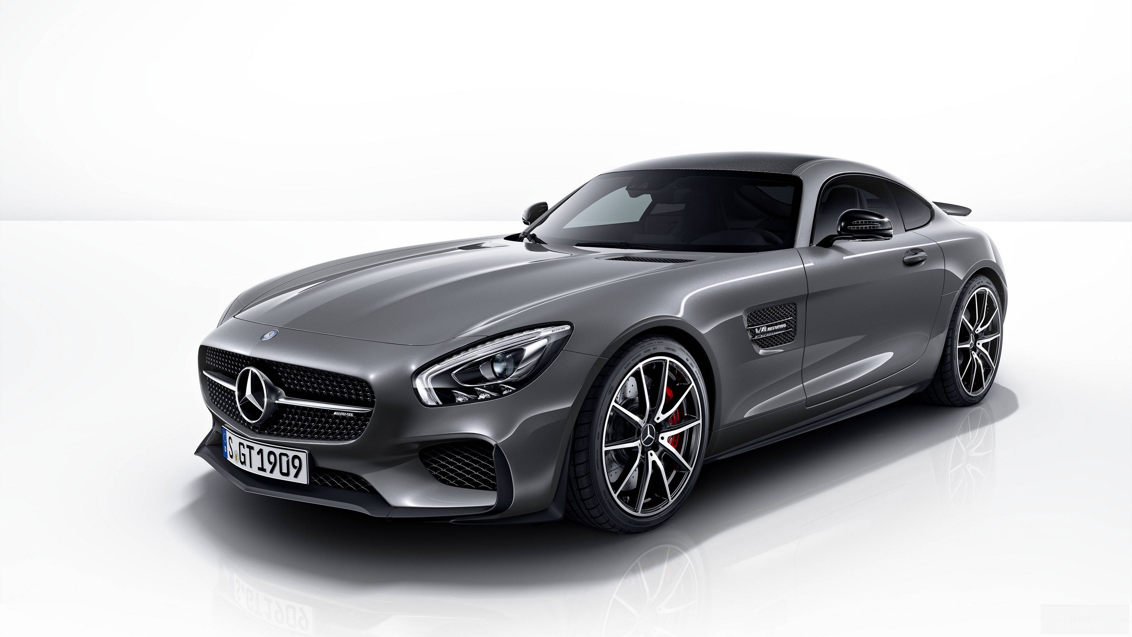 4K 奔馳壁紙 桌布 壁紙 — 一輛時尚的銀色 Mercedes-AMG GT 跑車在攝影棚燈光下，在純白反光地板上閃閃發光。