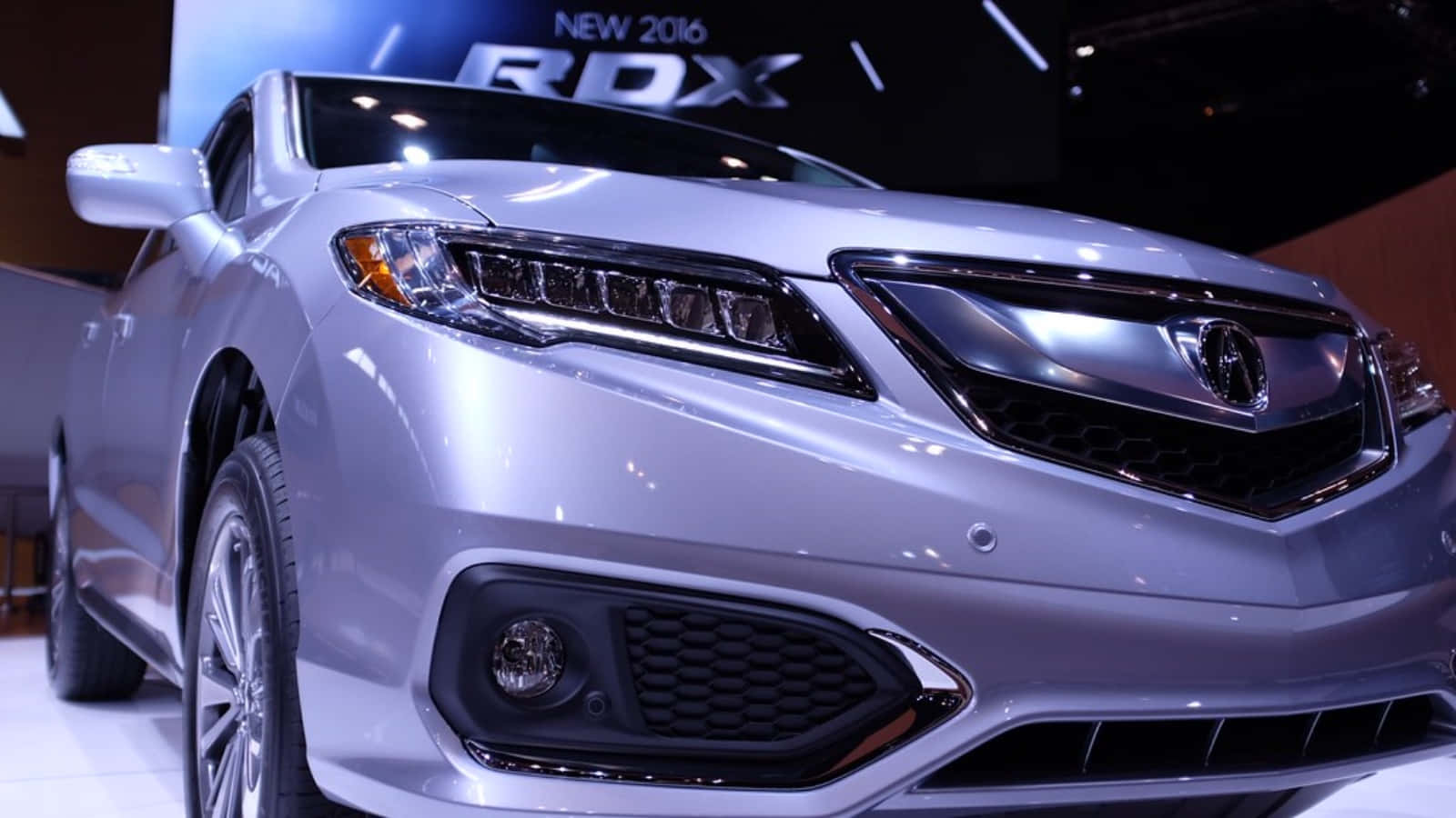 Acura 桌布 壁紙 — 一輛時尚的銀色2016年Acura RDX SUV在車展的明亮展廳燈光下閃閃發光。