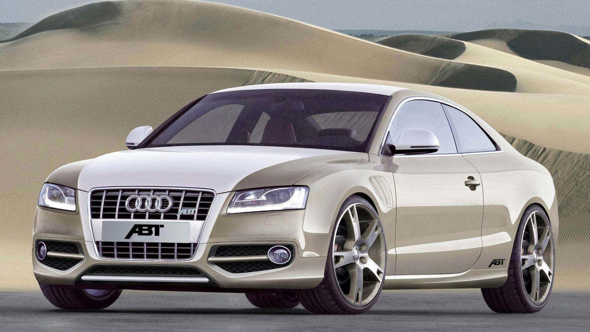cars 桌布 壁紙 — 一輛時尚的銀色ABT改裝奧迪A5轎跑車停在沙漠公路上，背景是連綿起伏的沙丘。