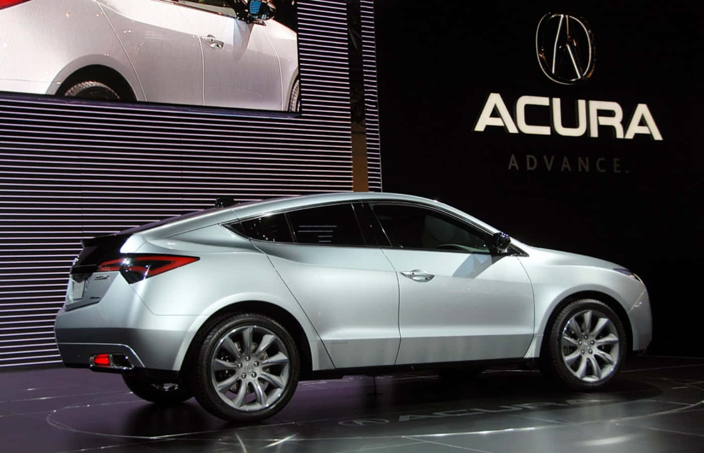 Acura 桌布 壁紙 — 一輛時尚的銀色Acura轎跑車在明亮的燈光下，在帶有品牌標誌背景的光澤舞台上閃閃發光。