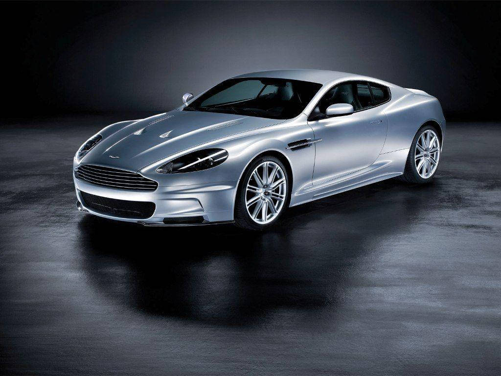 跑車 桌布 壁紙 — 一輛時尚的銀色Aston Martin DB9雙門跑車在攝影棚燈光下，在深色反光地板上閃閃發光。