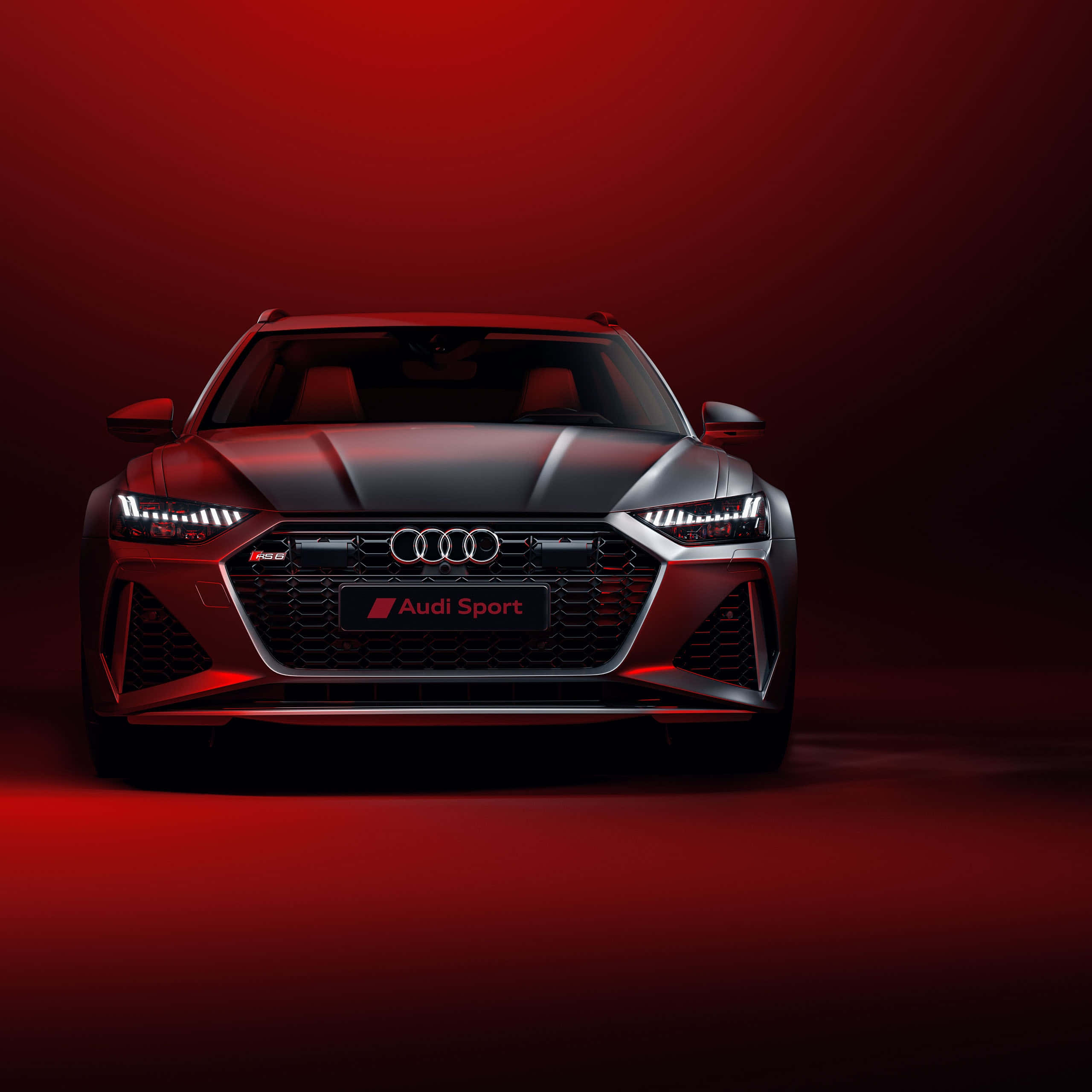 奧迪 桌布 壁紙 — 一輛時尚的銀色Audi Sport汽車在戲劇性的紅色工作室燈光下閃耀，背景為漸變色。