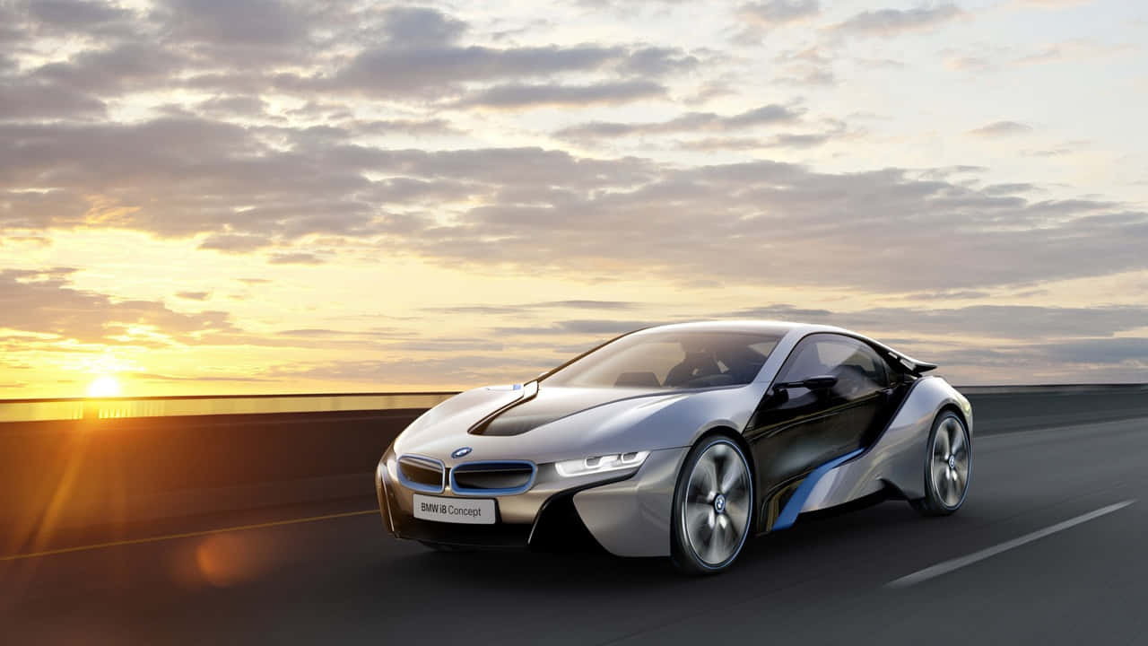 720p Bmw 桌布 壁紙 — 一輛時尚的銀色BMW i8 Concept跑車在日落時分沿著高速公路行駛，伴隨著金色的雲彩和發光的地平線。