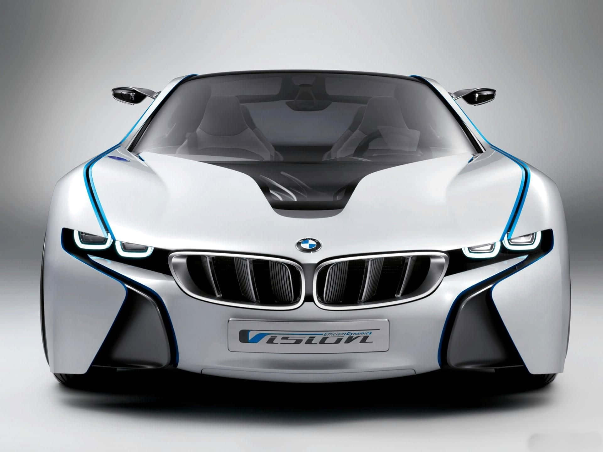 Bmw Cars 桌布 壁紙 — 一輛時尚的銀色BMW i8 Vision概念車，帶有發光的藍色裝飾和未來感車頭燈，在工作室環境中展示。