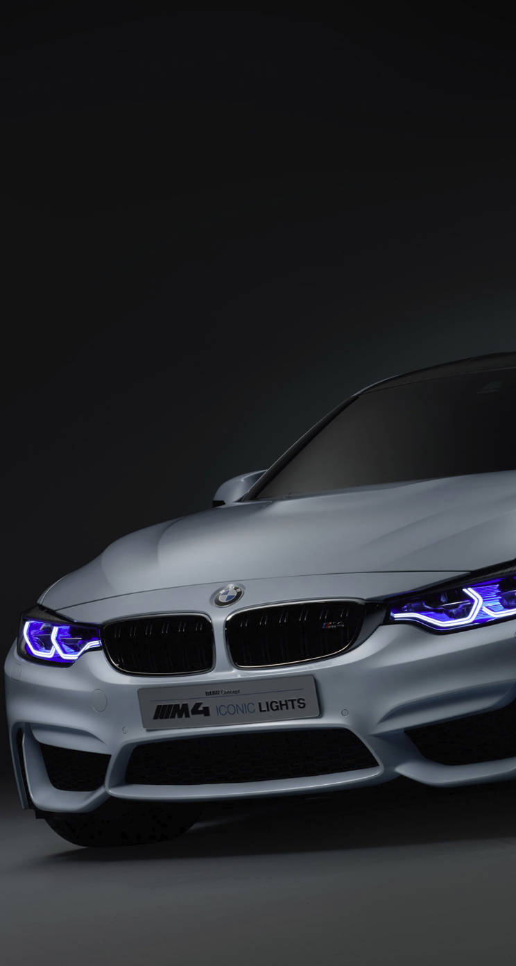 X 桌布 壁紙 — 一輛時尚的銀色BMW M4配備發光藍色頭燈，在黑暗的攝影棚背景下展示。