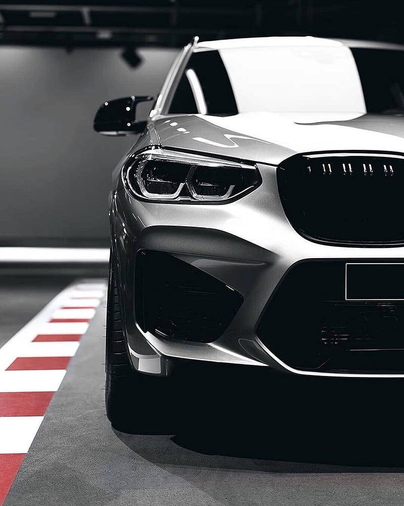 m 桌布 壁紙 — 一輛時尚的銀色BMW SUV主宰著一個光線昏暗、地板有紅白條紋的車庫。