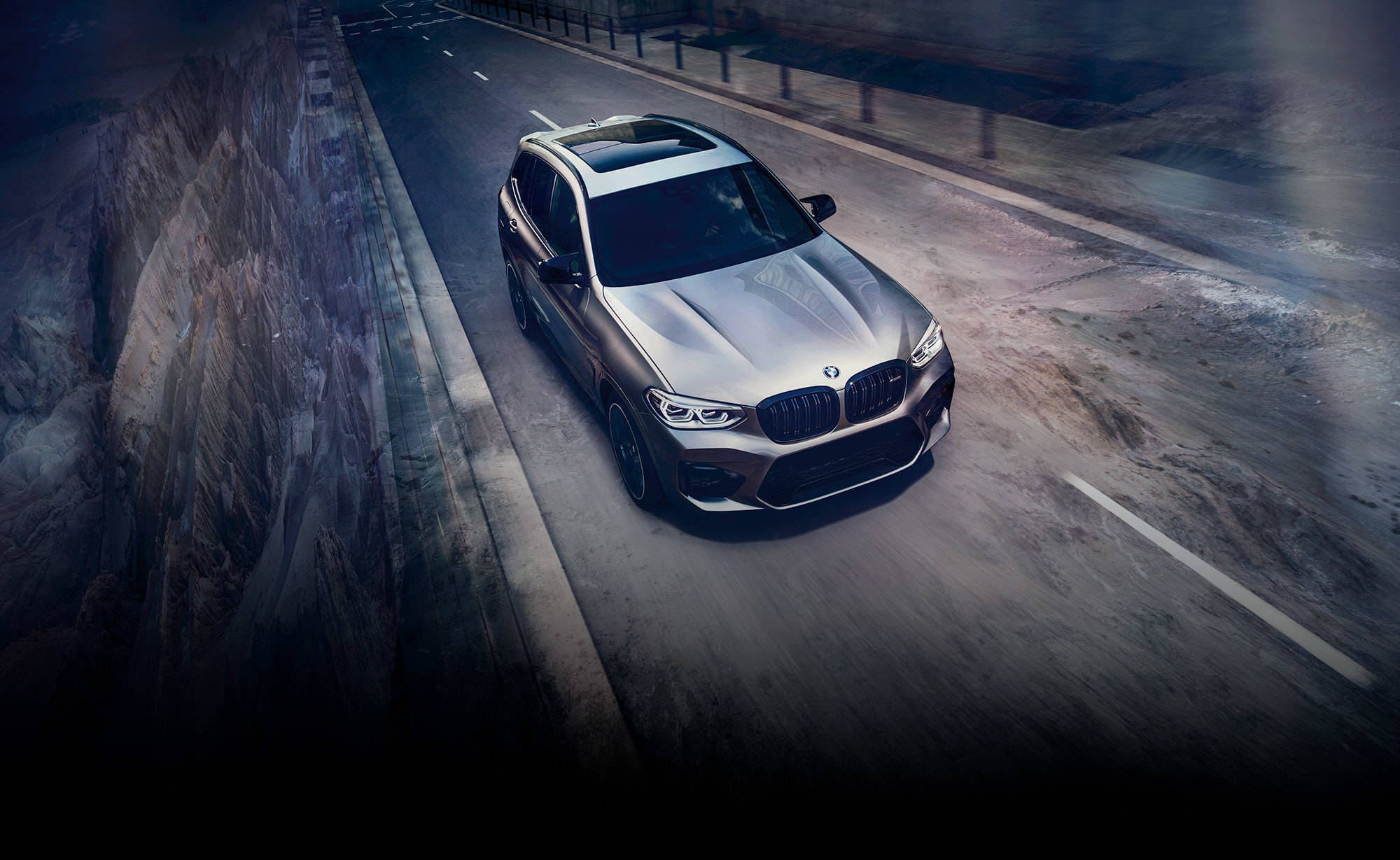 m 桌布 壁紙 — 一輛時尚的銀色BMW SUV在黃昏時分沿著蜿蜒的山路行駛，動態模糊強調了速度和力量。