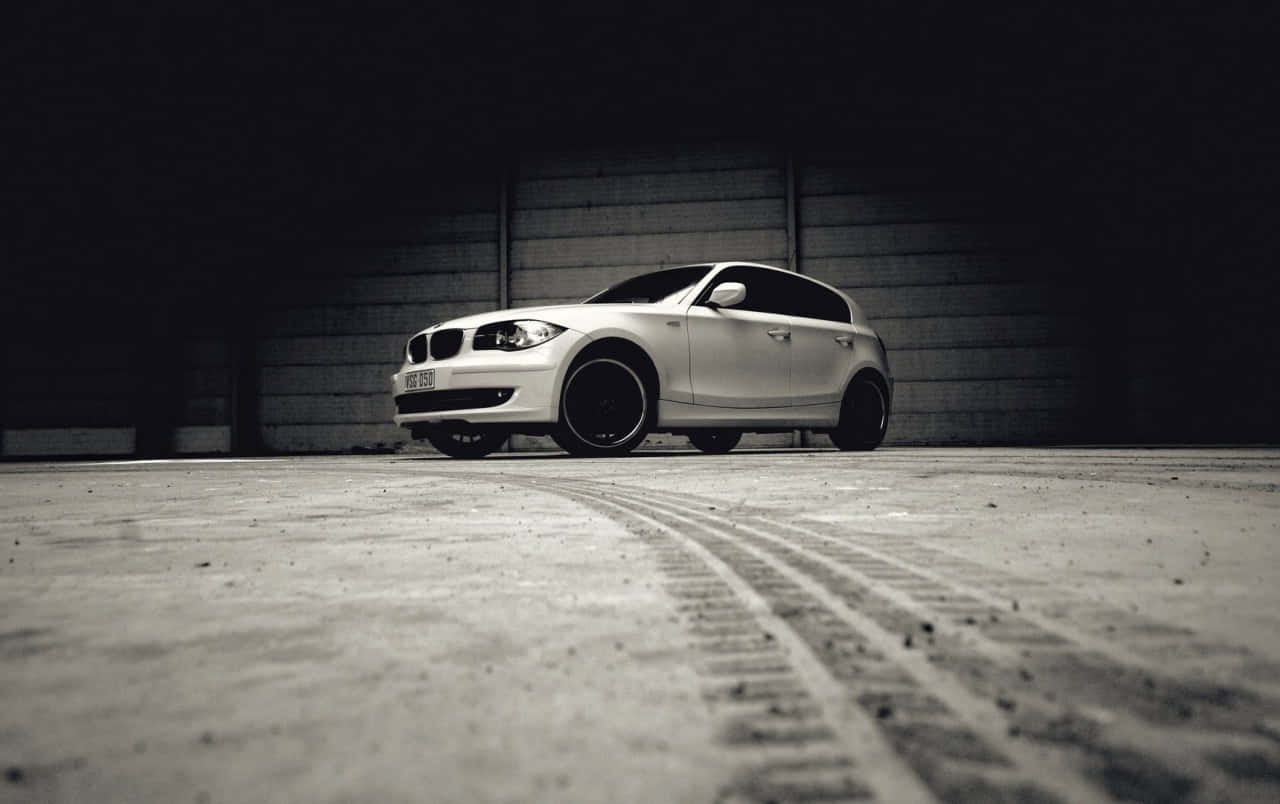 Bmw 1 Series 桌布 壁紙 — 一輛時尚的銀色BMW掀背車停在昏暗的混凝土車庫中，地板上有輪胎痕跡。