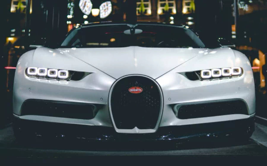 4K 桌布 壁紙 — 一輛時尚的銀色Bugatti Chiron在昏暗的城市車庫中，在霓虹燈下閃閃發光。