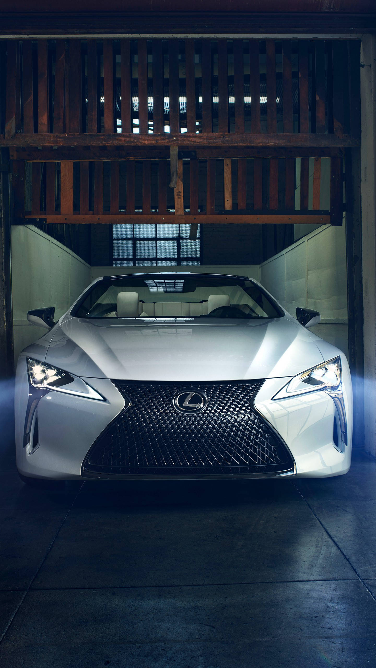 lexus iPhone 桌布 壁紙 — 一輛時尚的銀色Lexus跑車在質樸的木車庫內，在戲劇性的燈光下閃閃發光。
