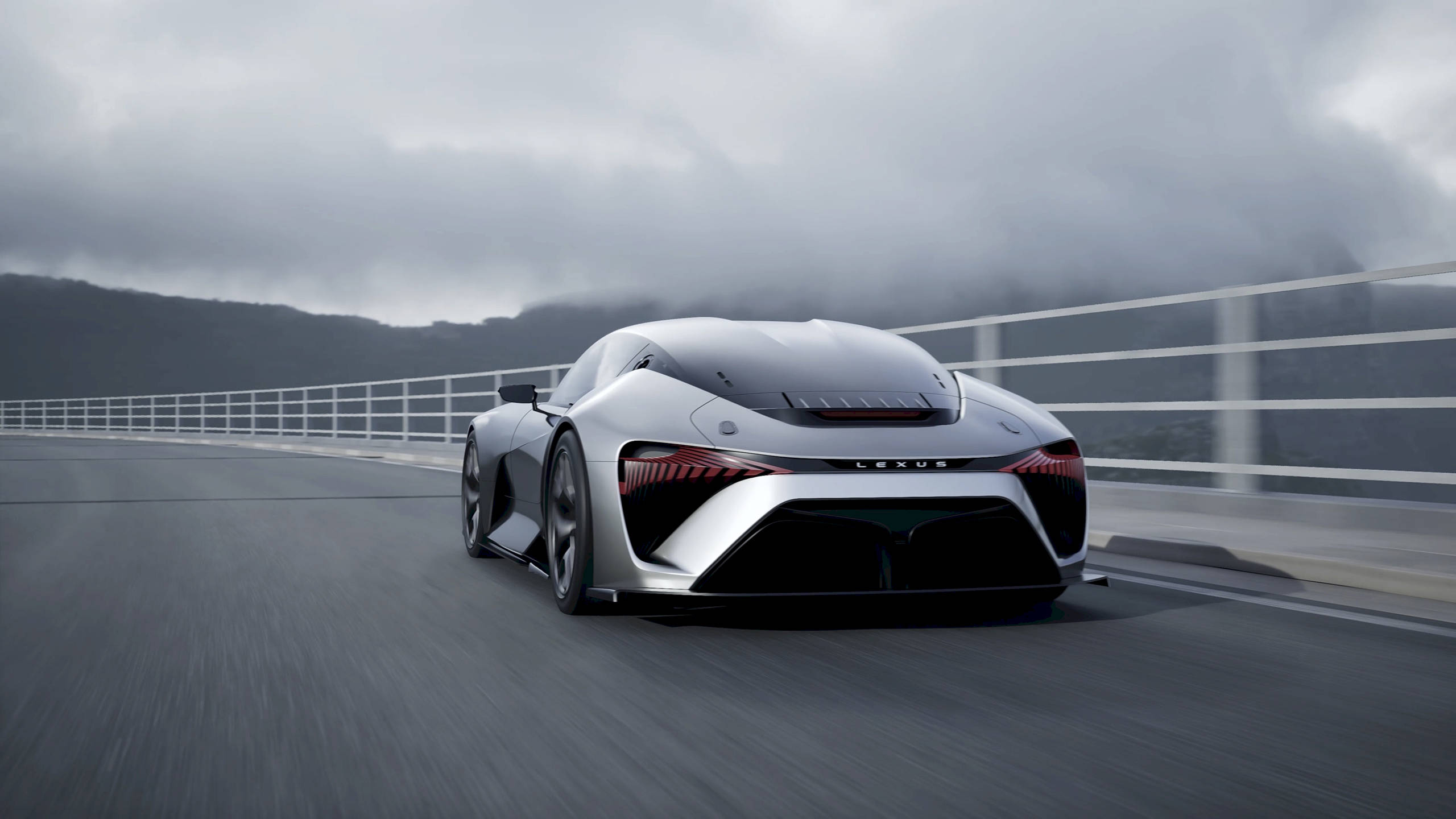 cars 桌布 壁紙 — 一輛時尚的銀色Lexus跑車在陰天下行駛在霧氣瀰漫的山區高速公路上。