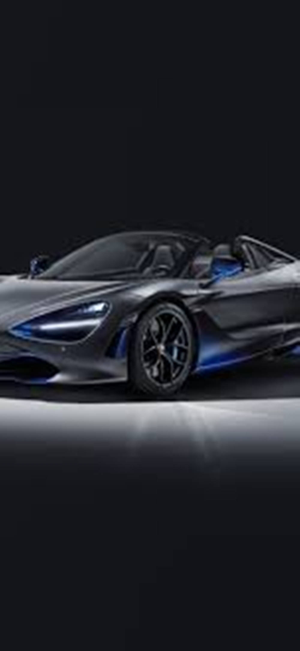 跑車 桌布 壁紙 — 一輛時尚的銀色McLaren 720S Spider，帶有發光的藍色點綴，在黑色背景下戲劇性地照亮。