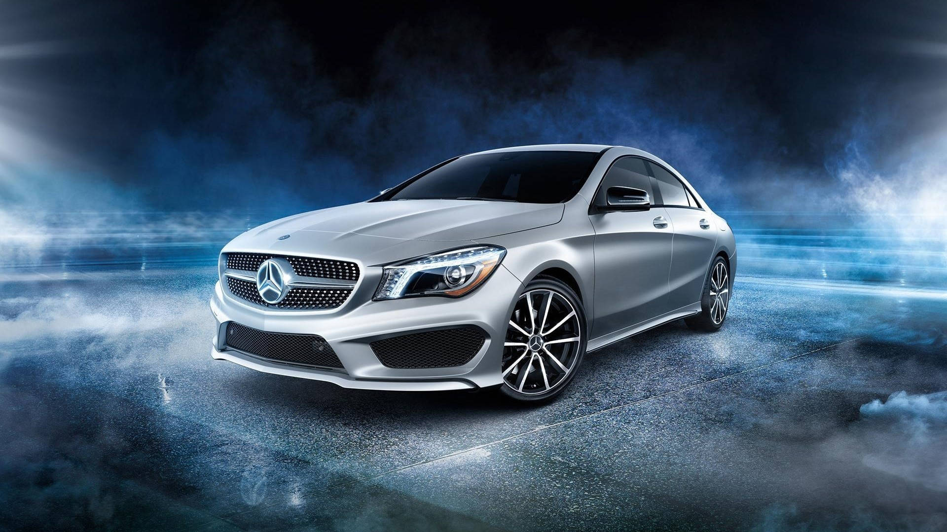 桌布 壁紙 — 一輛時尚的銀色Mercedes-Benz CLA轎車在煙霧瀰漫的藍色隧道中滑行，帶有戲劇性的燈光和動態模糊效果。