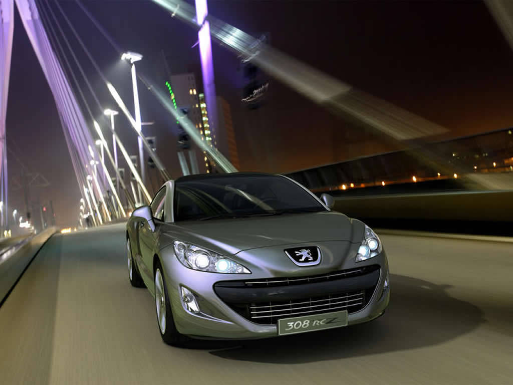 Peugeot 桌布 壁紙 — 一輛時尚的銀色Peugeot 308 RCZ在夜間高速駛過現代化的照明橋樑，帶有動態模糊痕跡。