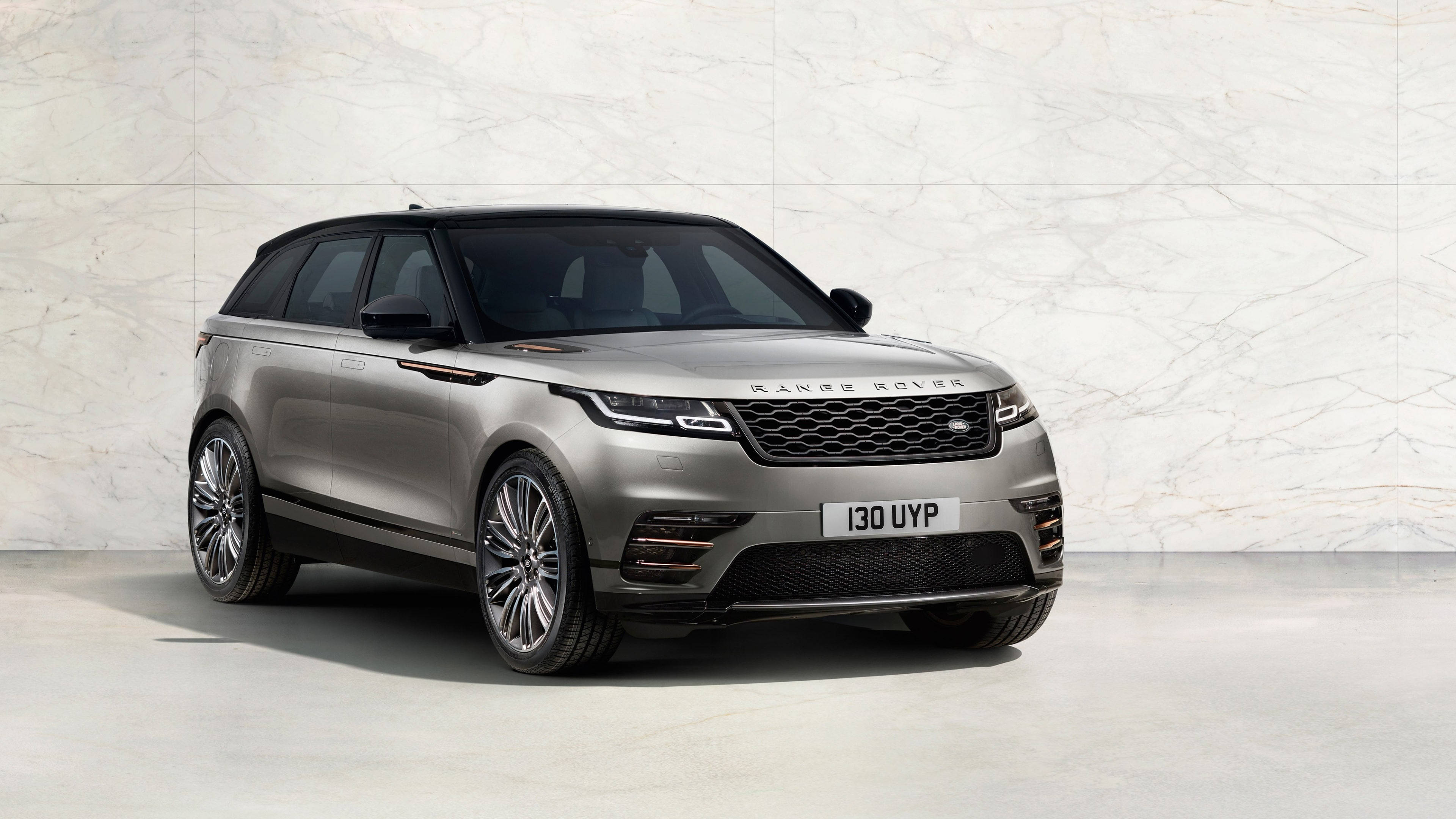 高清 桌布 壁紙 — 一輛時尚的銀色Range Rover SUV在攝影棚內，停放在極簡風格的大理石牆前。