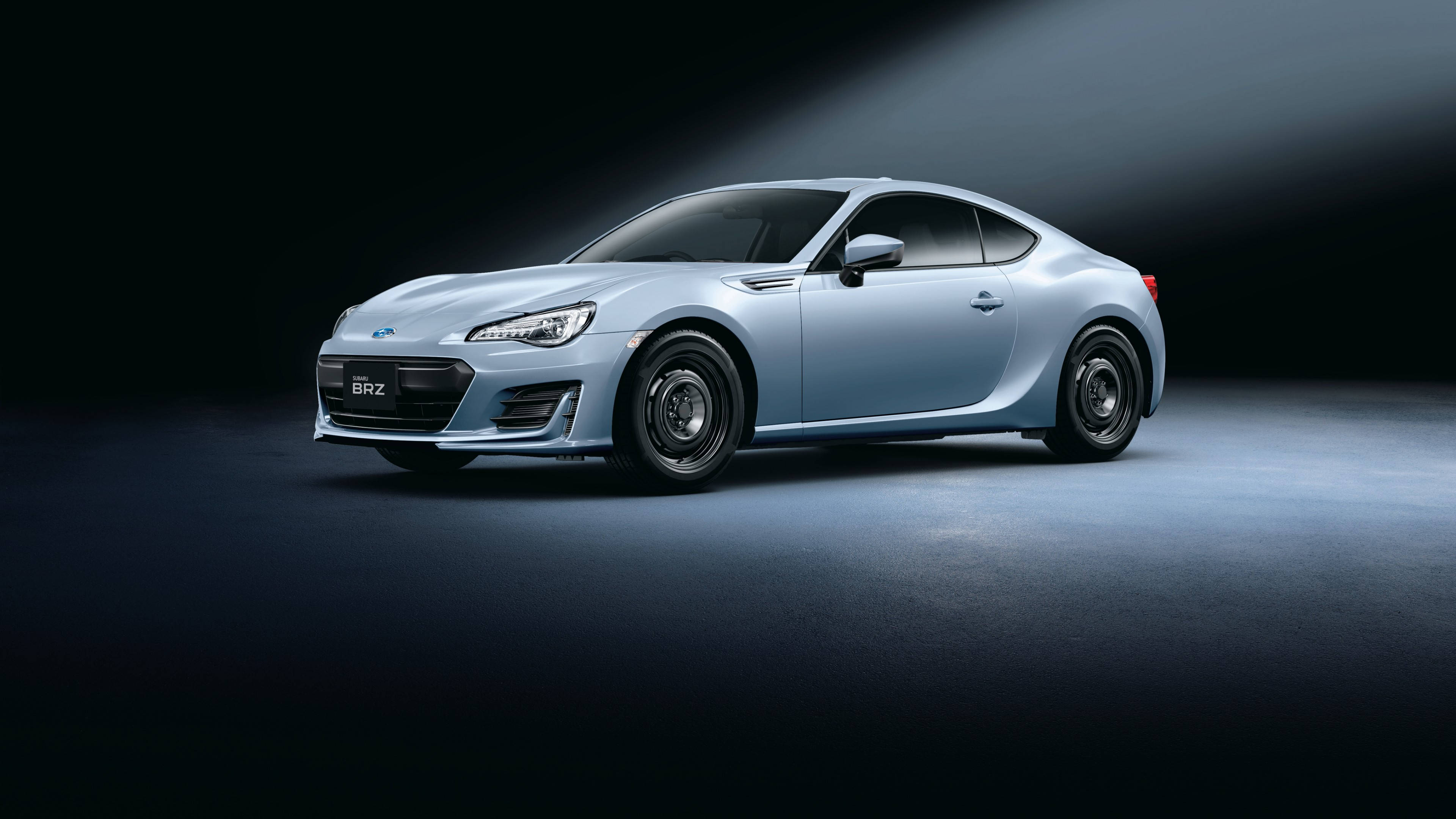 昴 桌布 壁紙 — 一輛時尚的銀色Subaru BRZ跑車在黑暗的攝影棚背景下，在戲劇性的聚光燈下閃耀。