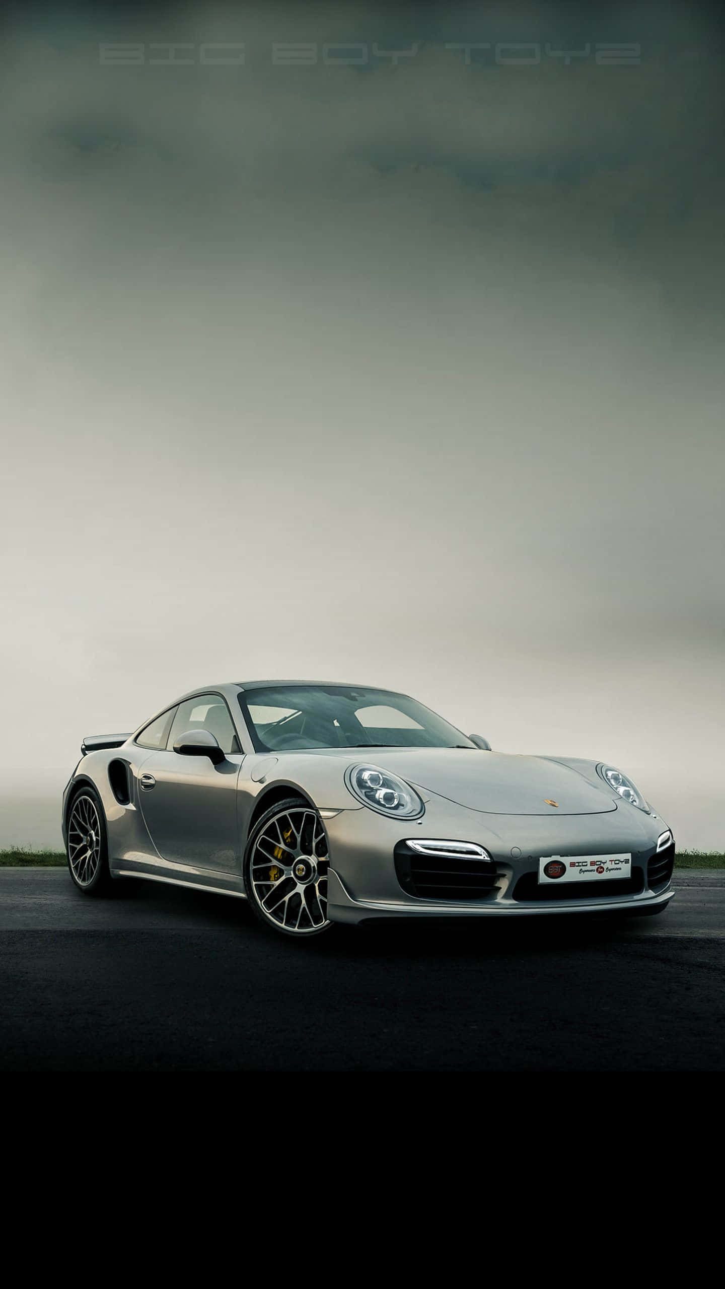 Best Cars 桌布 壁紙 — 一輛時尚的銀色保時捷911 Turbo S在陰暗多雲的天空下，停泊在漆黑的公路上。