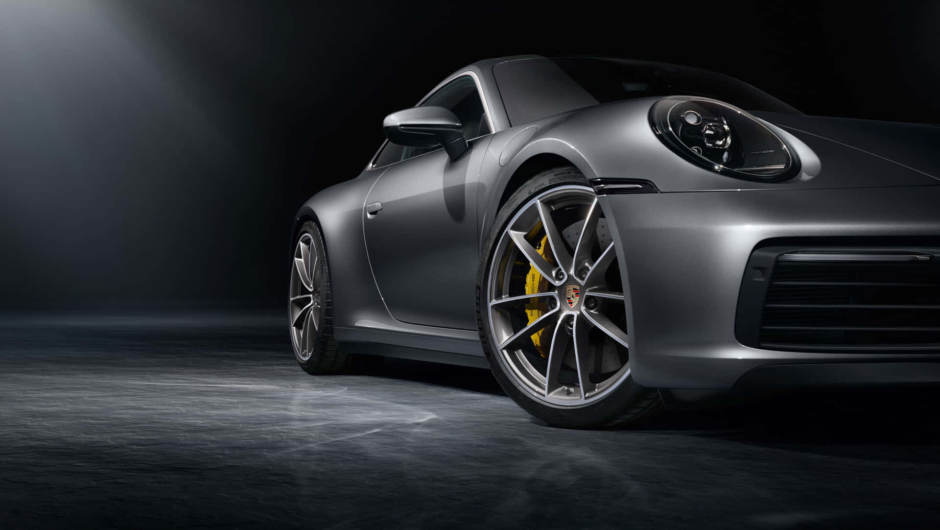 銀色保時捷911跑車，帶黃色制動卡鉗，在黑暗的攝影棚燈光下。 — 保時捷 GIF 壁紙