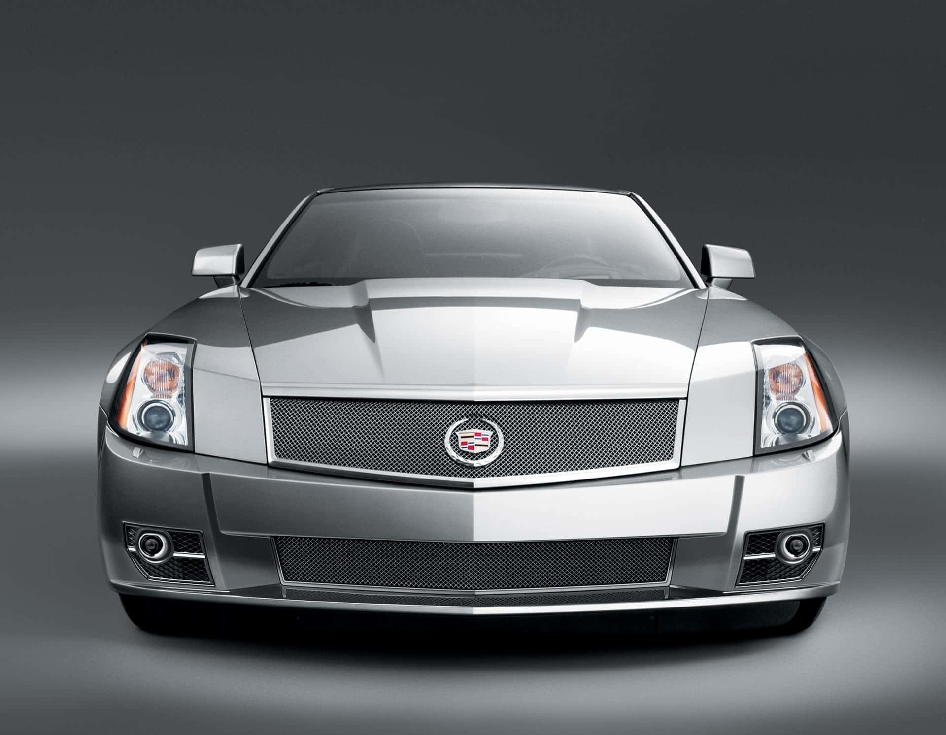 Cadillac Xlr 桌布 壁紙 — 一輛時尚的銀色凱迪拉克跑車正面朝前，背景是漸變灰色攝影棚，光線銳利。