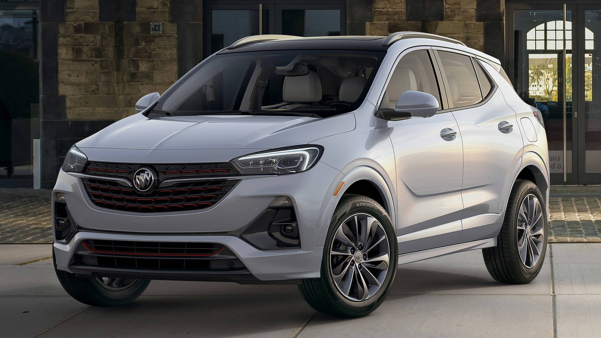 Buick 桌布 壁紙 — 一輛時尚的銀色別克SUV停放在石造建築前的人行道上，建築物有玻璃門。