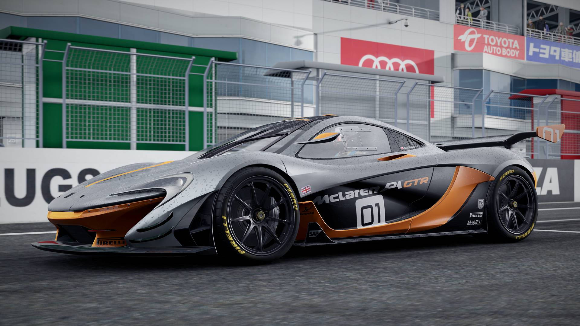 cars 桌布 壁紙 — 一輛時尚的銀色和橙色McLaren 01 GTR賽車停在賽道上，背景有贊助商橫幅和安全護欄。
