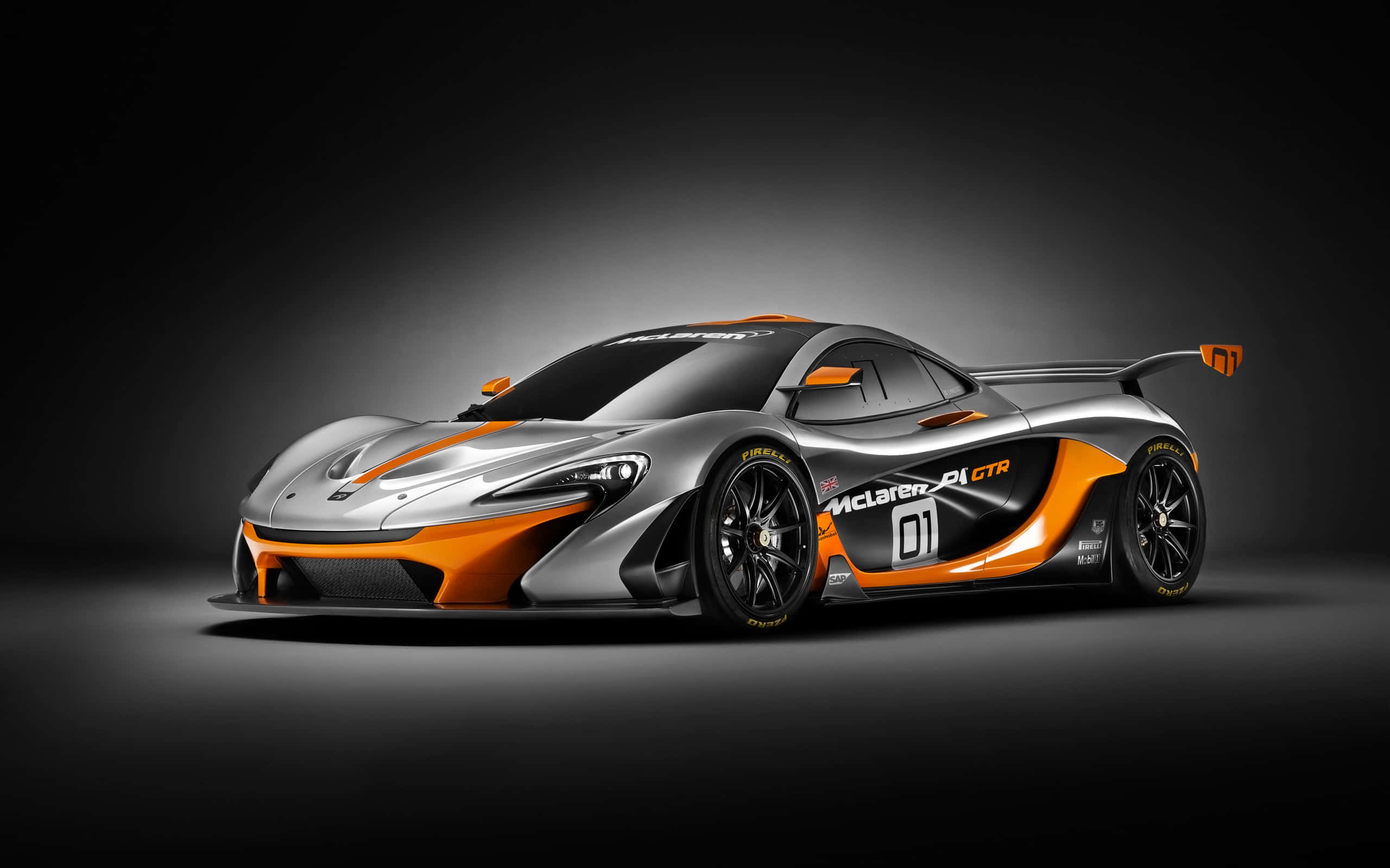 Cool Mclaren 桌布 壁紙 — 一輛時尚的銀色和橙色McLaren 600LT GTR賽車在攝影棚燈光下，在深色漸變背景上閃耀。