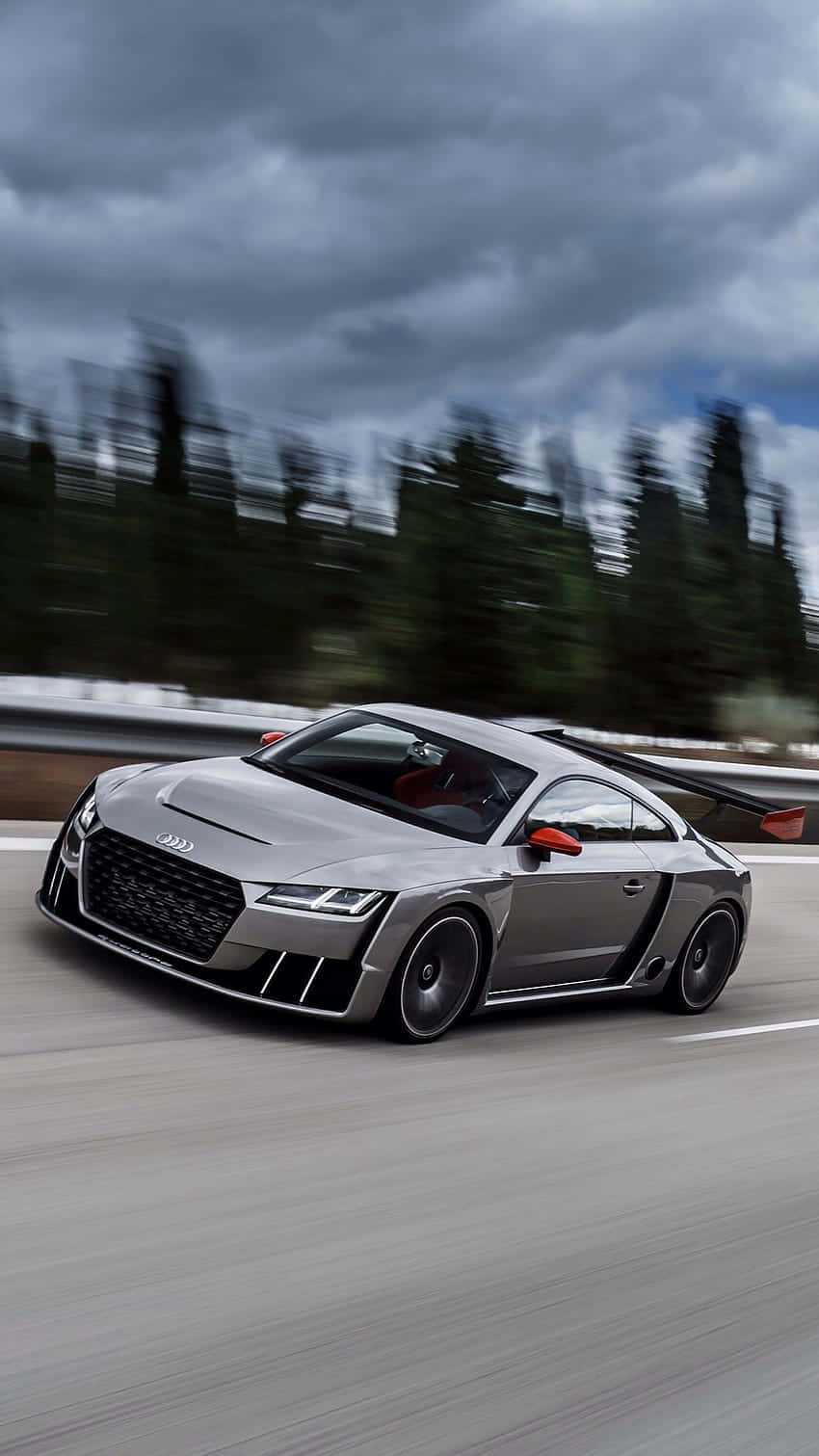 Audi Tt Rs 桌布 壁紙 — 一輛時尚的銀色奧迪R8 GT在高速公路上疾馳，伴隨著動態模糊的樹木和頭頂的烏雲。