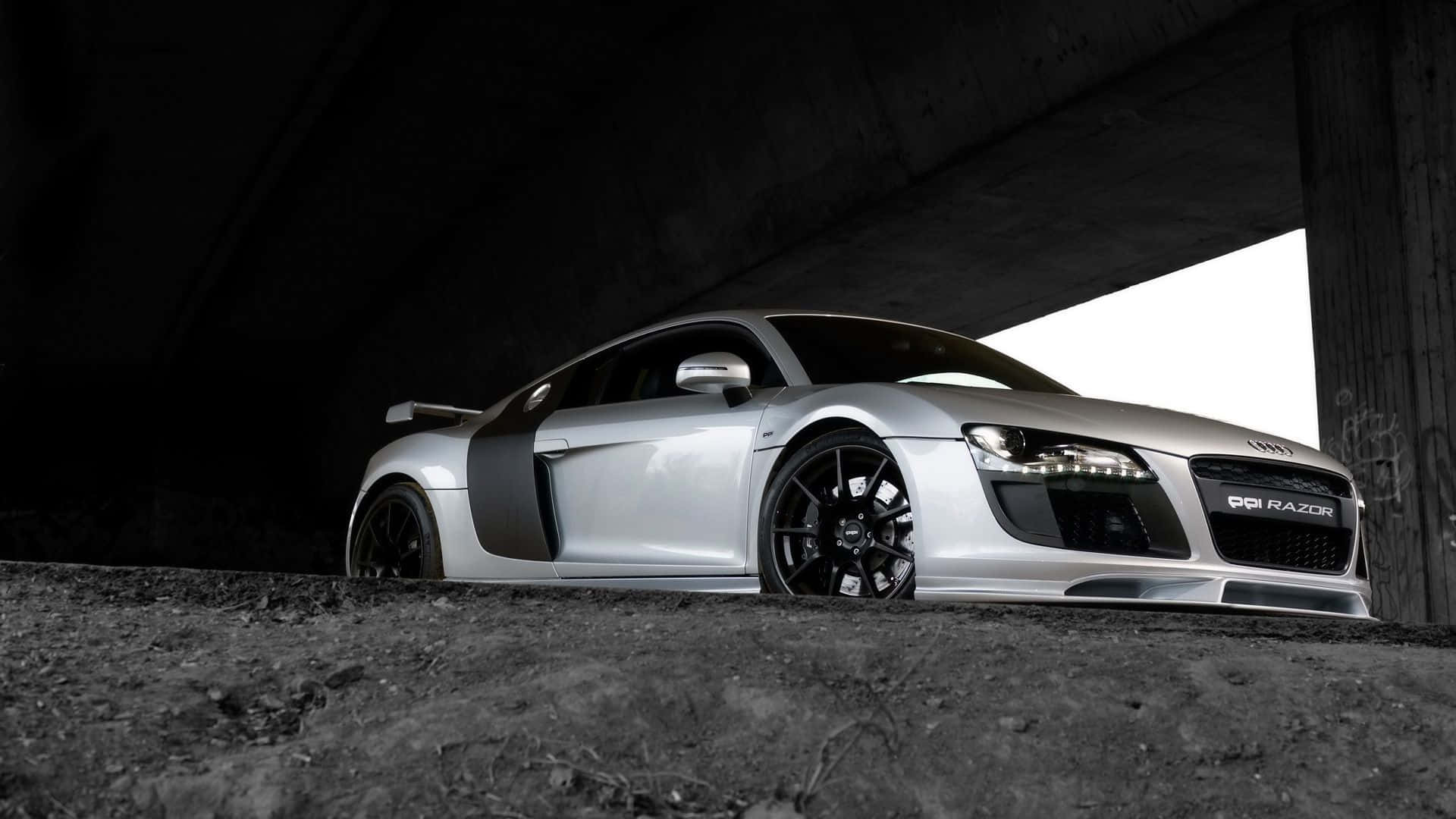 Audi Tt 桌布 壁紙 — 一輛時尚的銀色奧迪R8跑車，帶有黑色飾邊，停在混凝土天橋下，光線效果戲劇化。