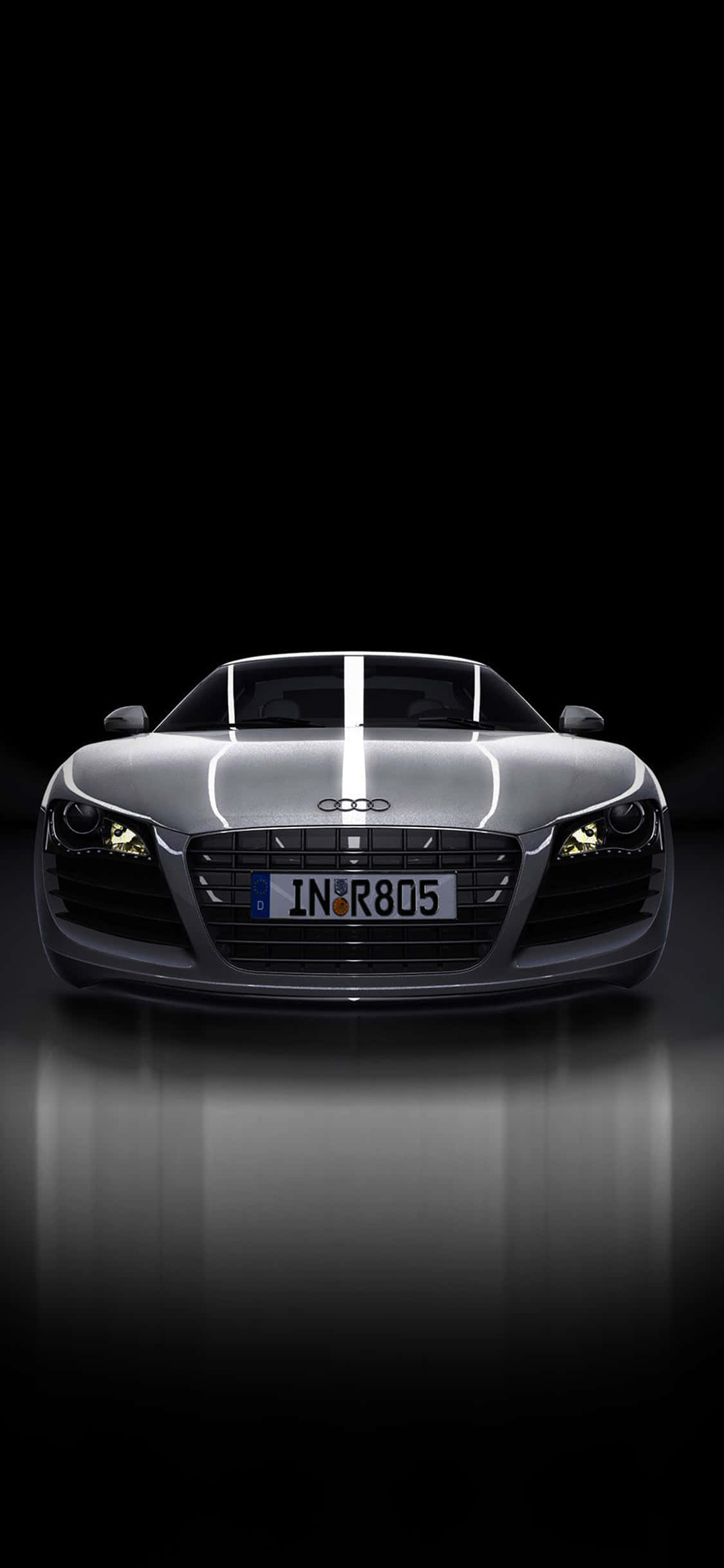 Audi iPhone 桌布 壁紙 — 一輛時尚的銀色奧迪R8跑車在黑色背景和反光地板的攝影棚燈光下閃閃發光。