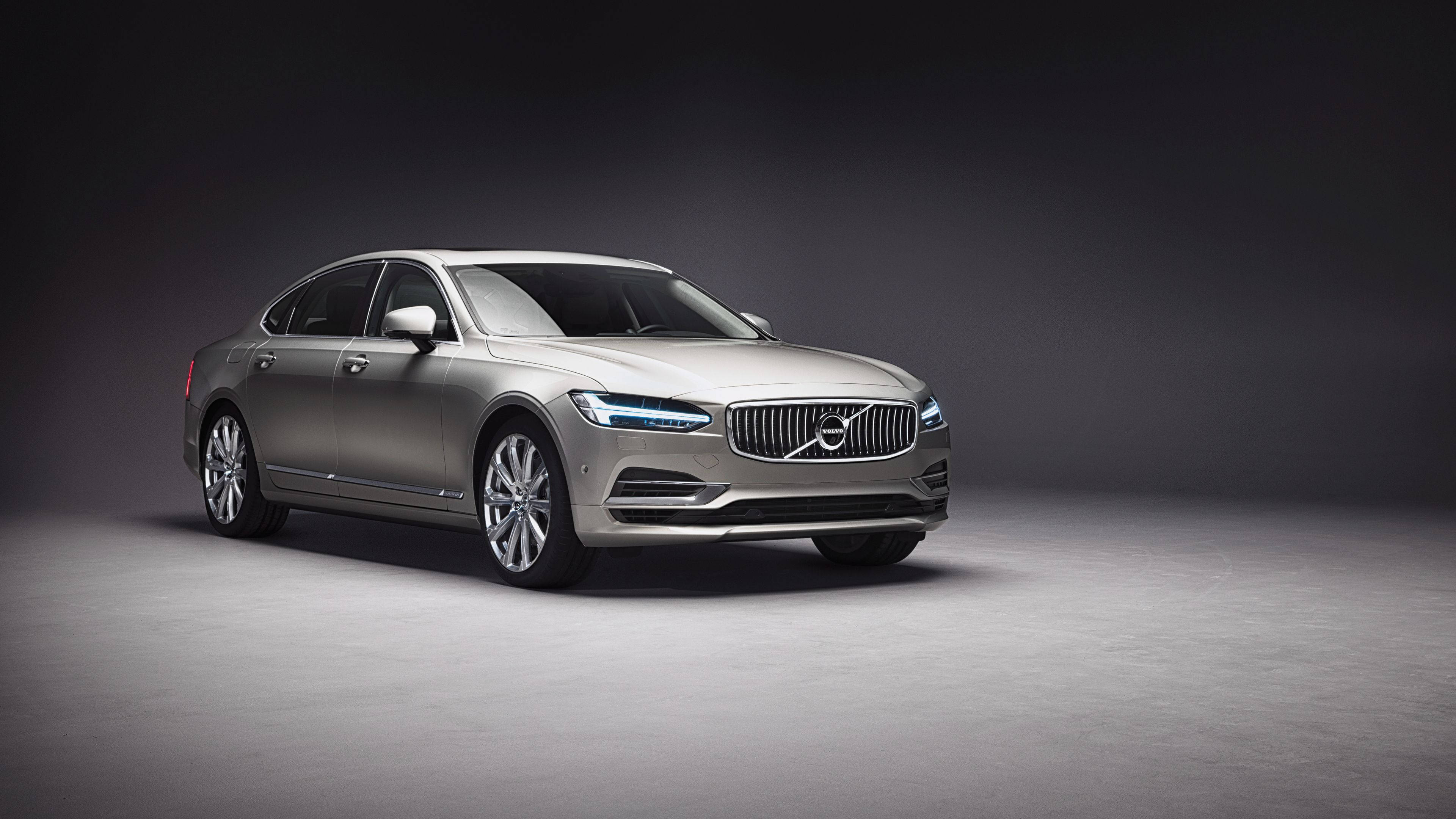 Volvo 桌布 壁紙 — 一輛時尚的銀色富豪房車在攝影棚燈光下閃閃發光，背景為深色漸變。
