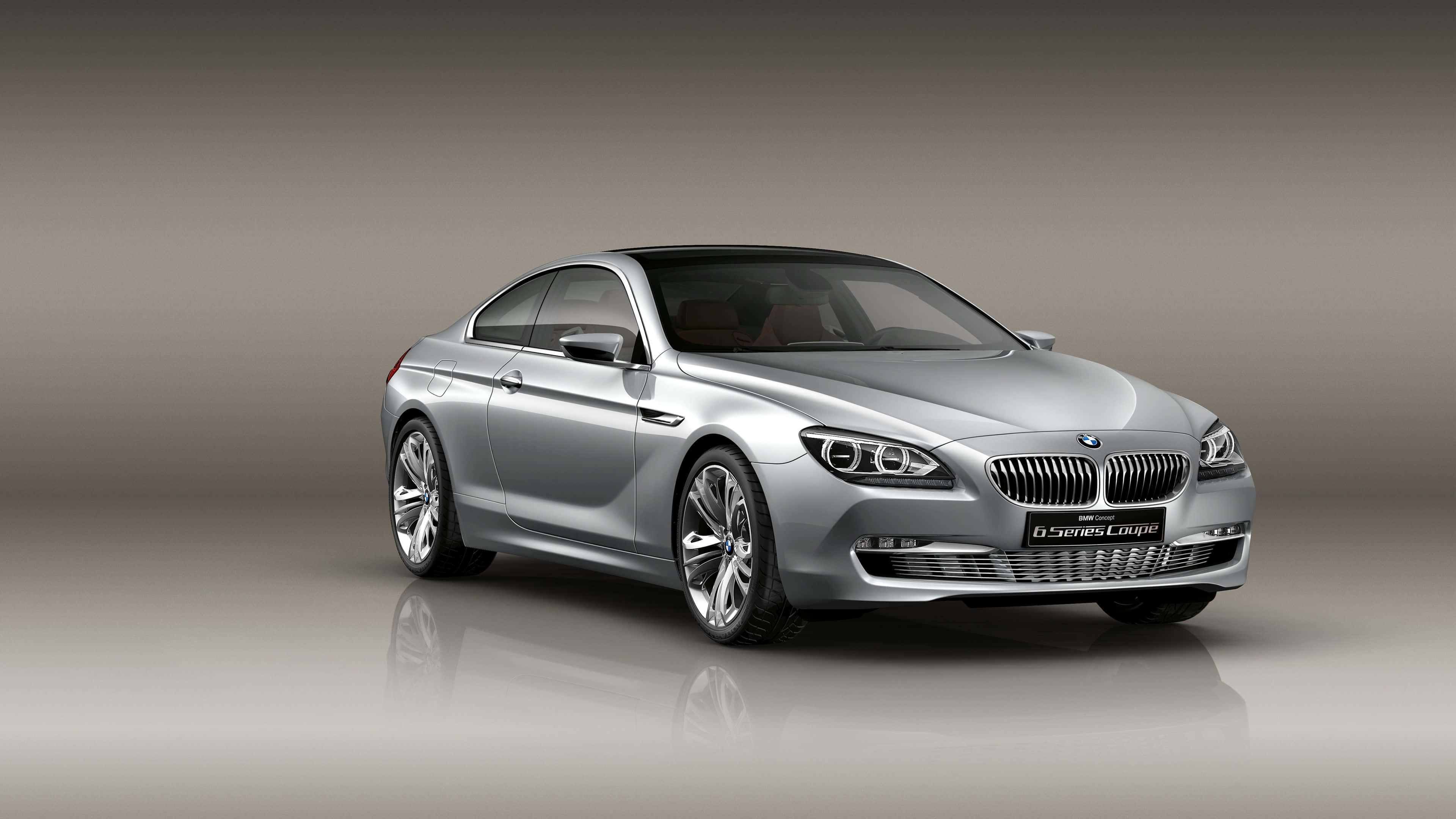 Bmw 6 Series 桌布 壁紙 — 一輛時尚的銀色寶馬6系轎跑車在攝影棚燈光下閃耀，配以反光地板和漸變灰色背景。