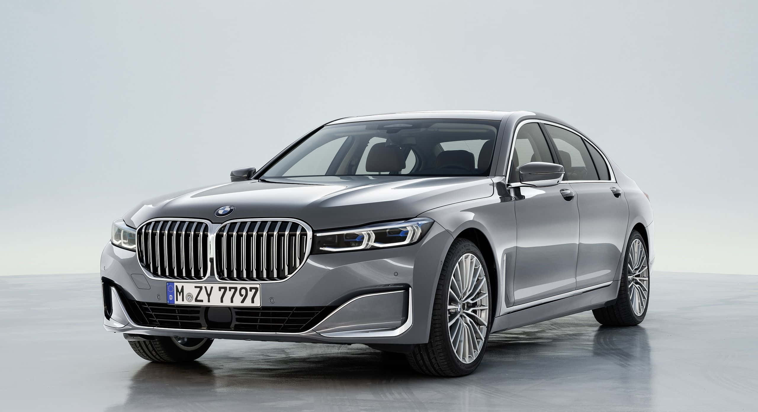 Bmw 7 Series 桌布 壁紙 — 一輛時尚的銀色寶馬7系列轎車在攝影棚燈光下，在極簡灰色背景前閃閃發光。