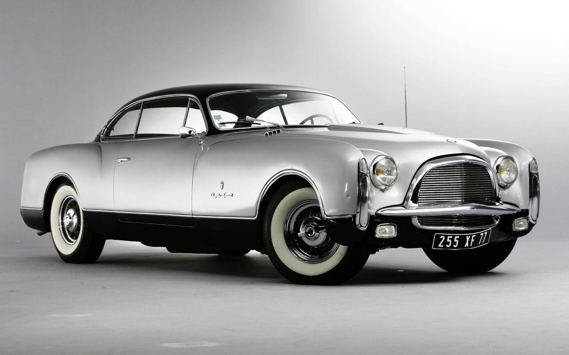 Chrysler 桌布 壁紙 — 一輛時尚的銀色復古愛快羅密歐2500 Coupe，黑色車頂和白色輪胎，在灰色工作室背景前擺拍。